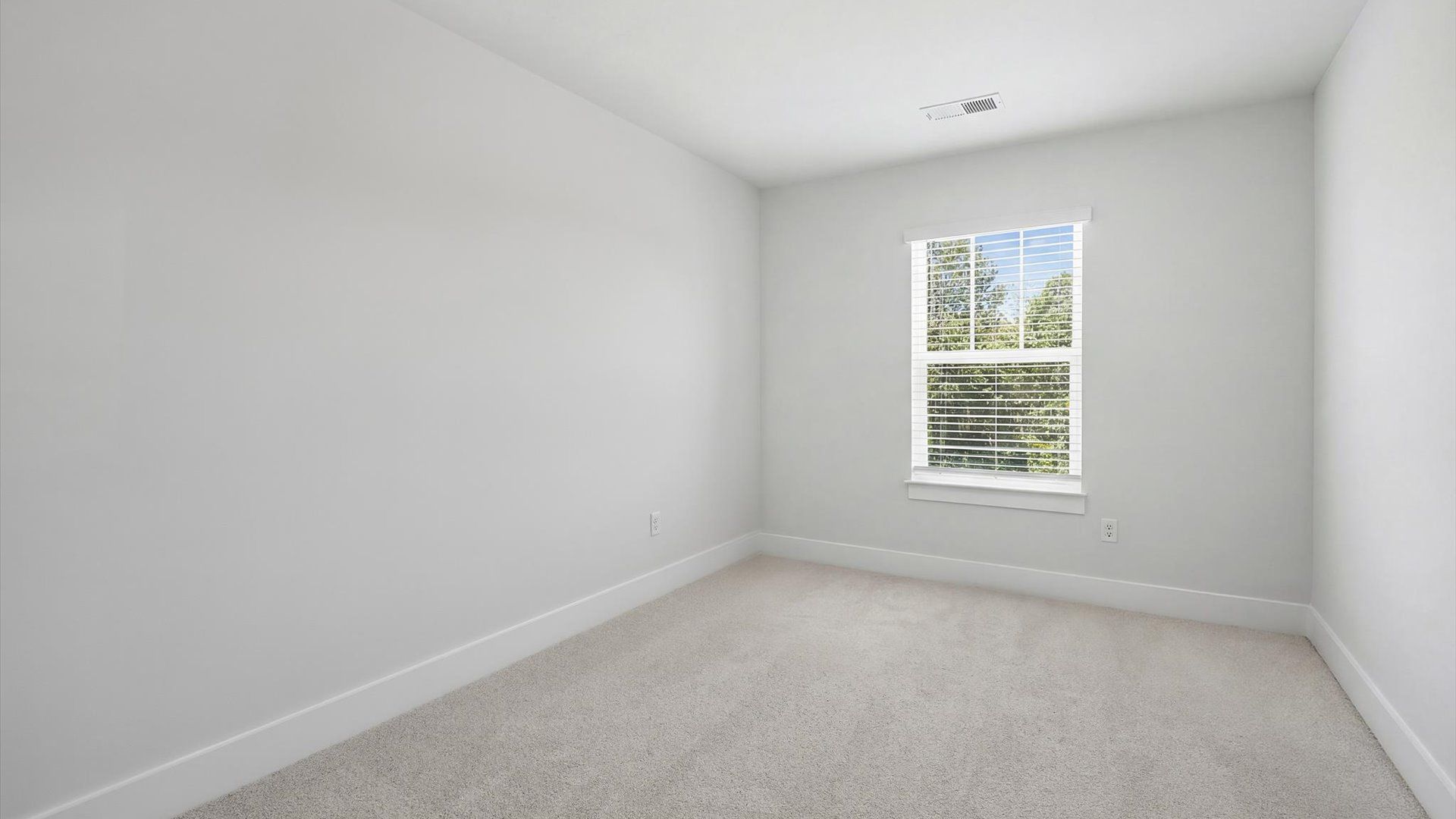 Notable bedroom offering soft carpet, a walk-in closet, and expansive windows overlooking the yard near Downtown Greenville