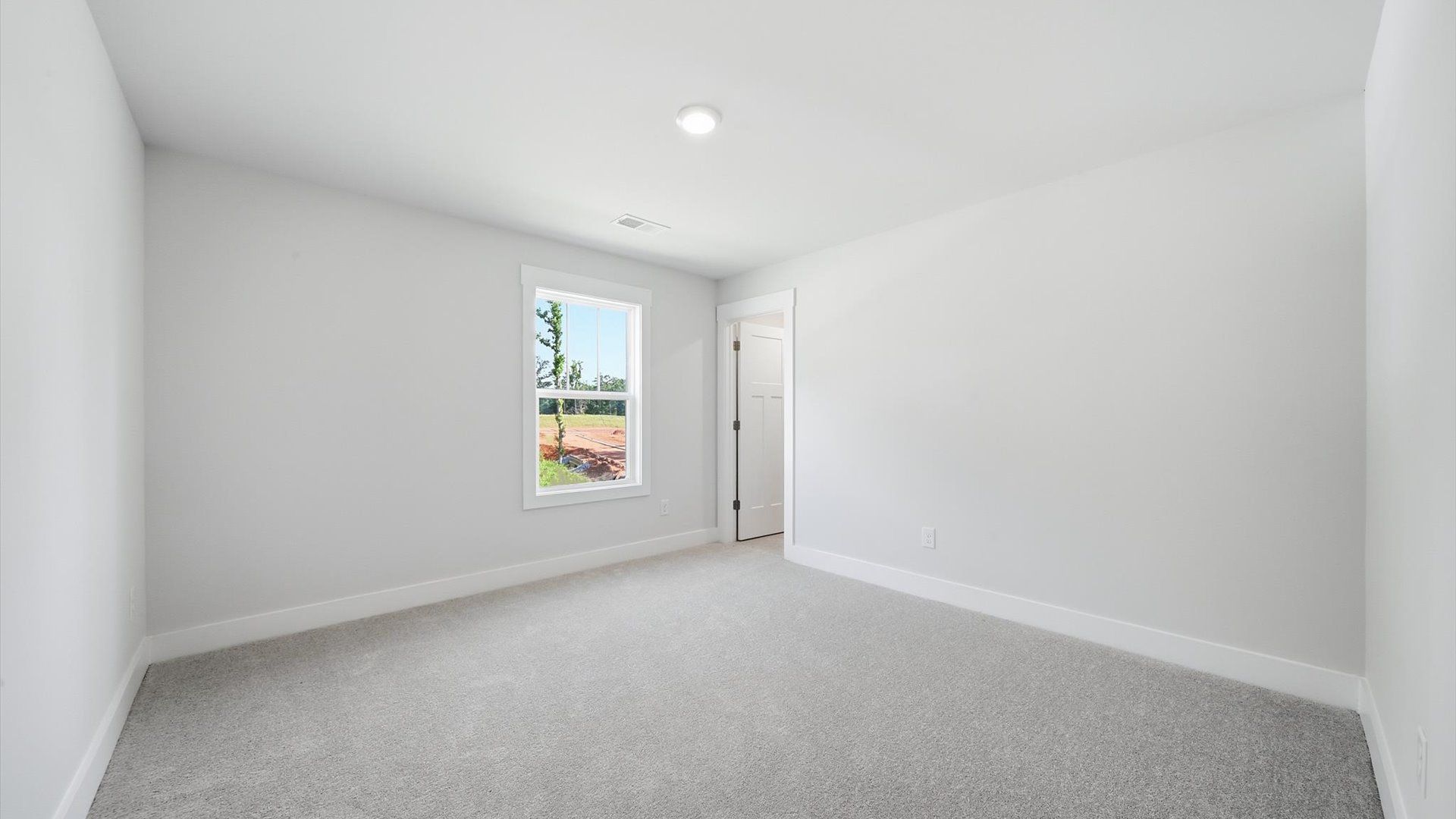 Inviting bedroom with tasteful finishes and large windows that create a fresh, open ambiance by DRB Homes