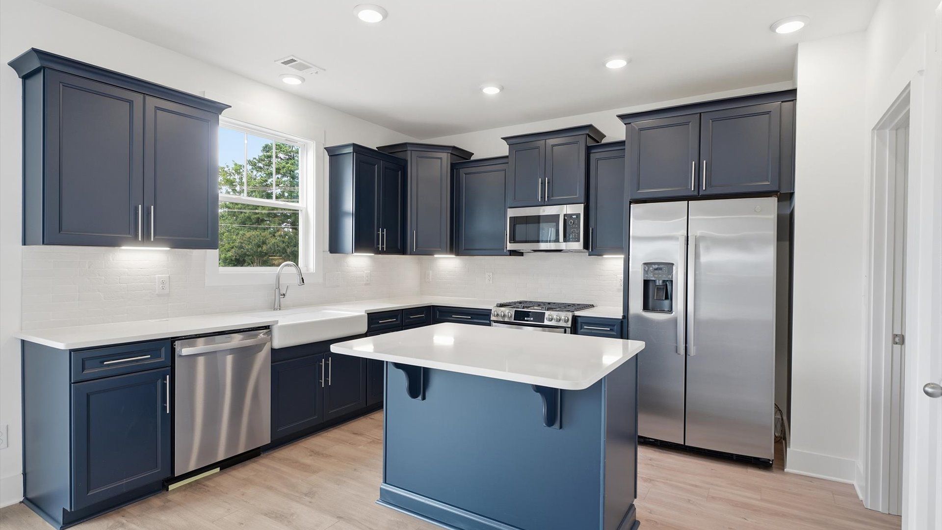 Light-filled kitchen with a center island and effortless connection to living areas by DRB Homes