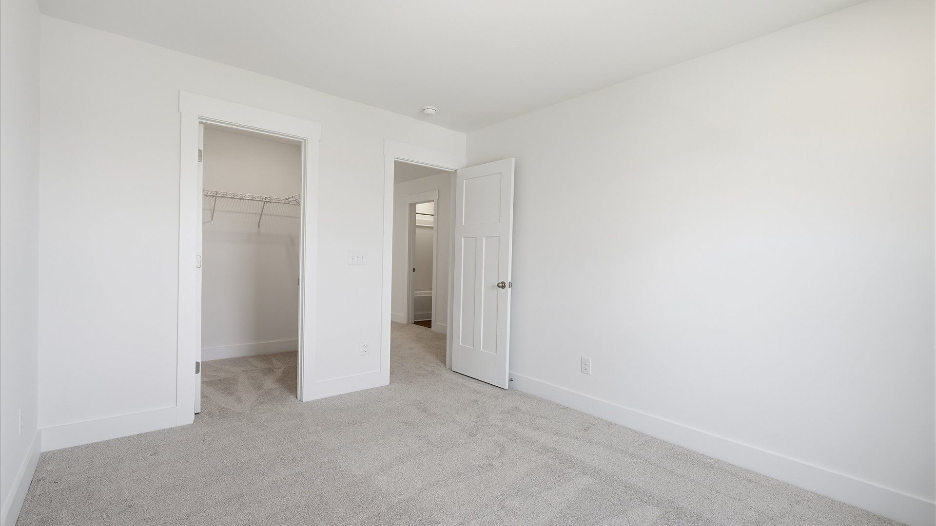 Notable secondary bedroom offering cozy carpeted flooring and a stylish walk-in closet at Iris Meadows