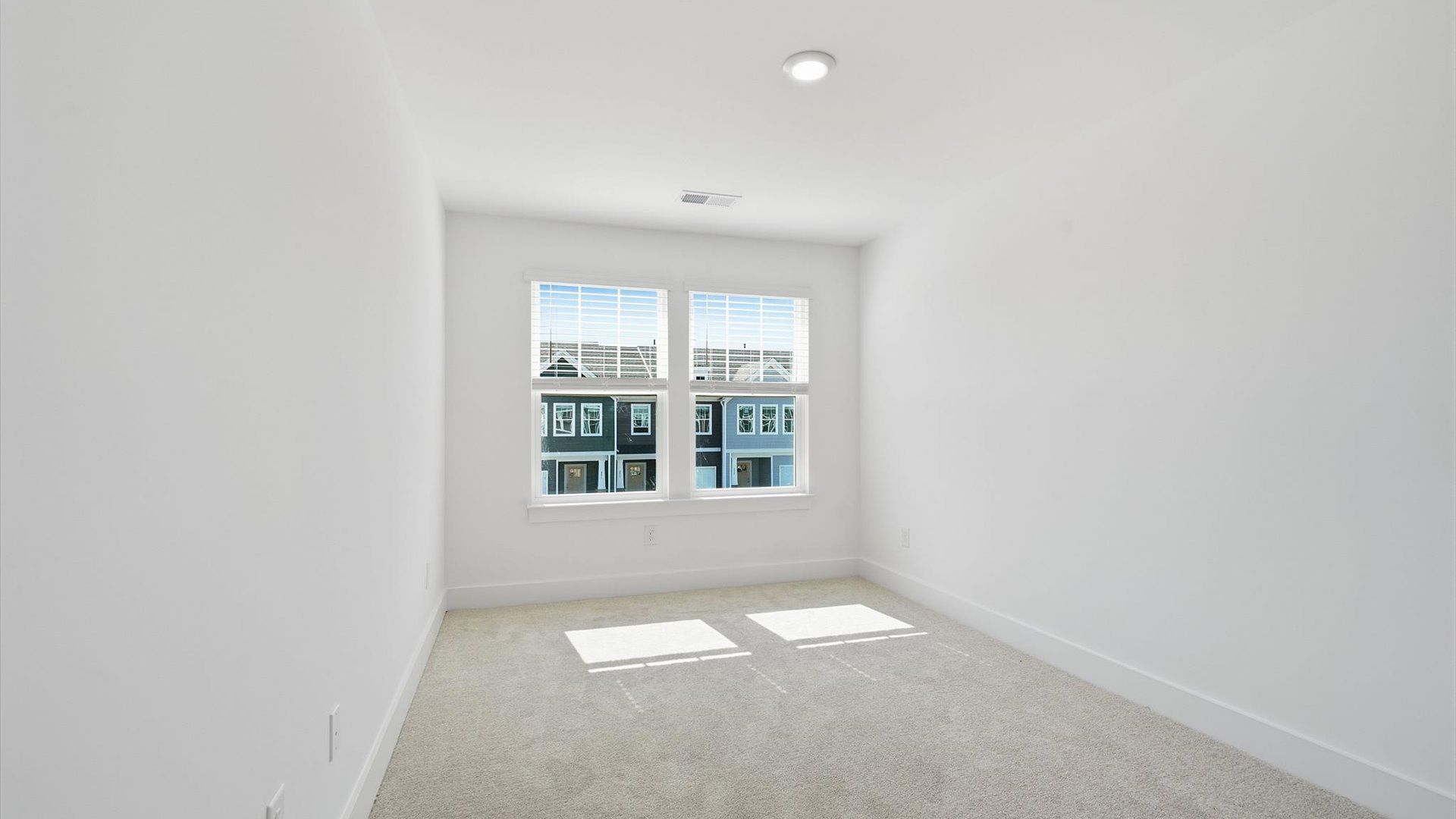 Highly functional bedroom with large windows, carpeted flooring, and tasteful finishes throughout by DRB Homes