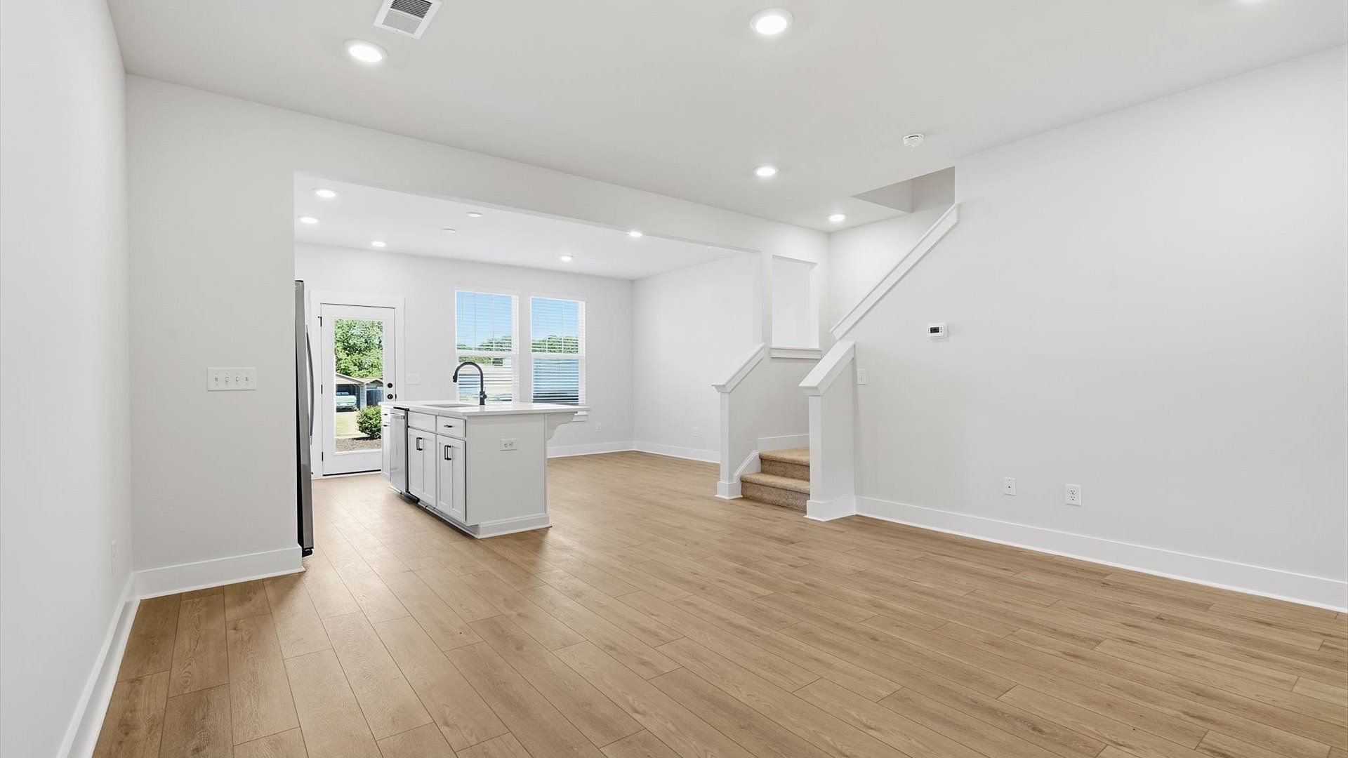 First-rate living space with tasteful hardwood floors and a functional open-concept design by DRB Homes