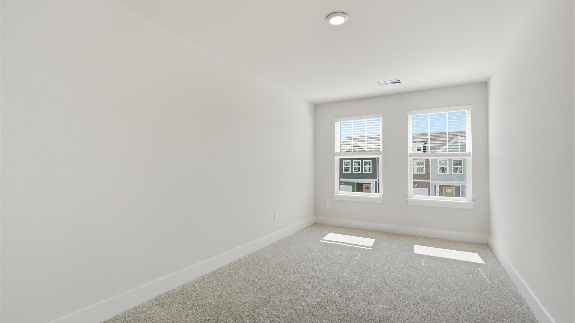 Accomplished bedroom layout with cozy carpet, a spacious walk-in closet, and sun-filled windows at Saluda Crossing