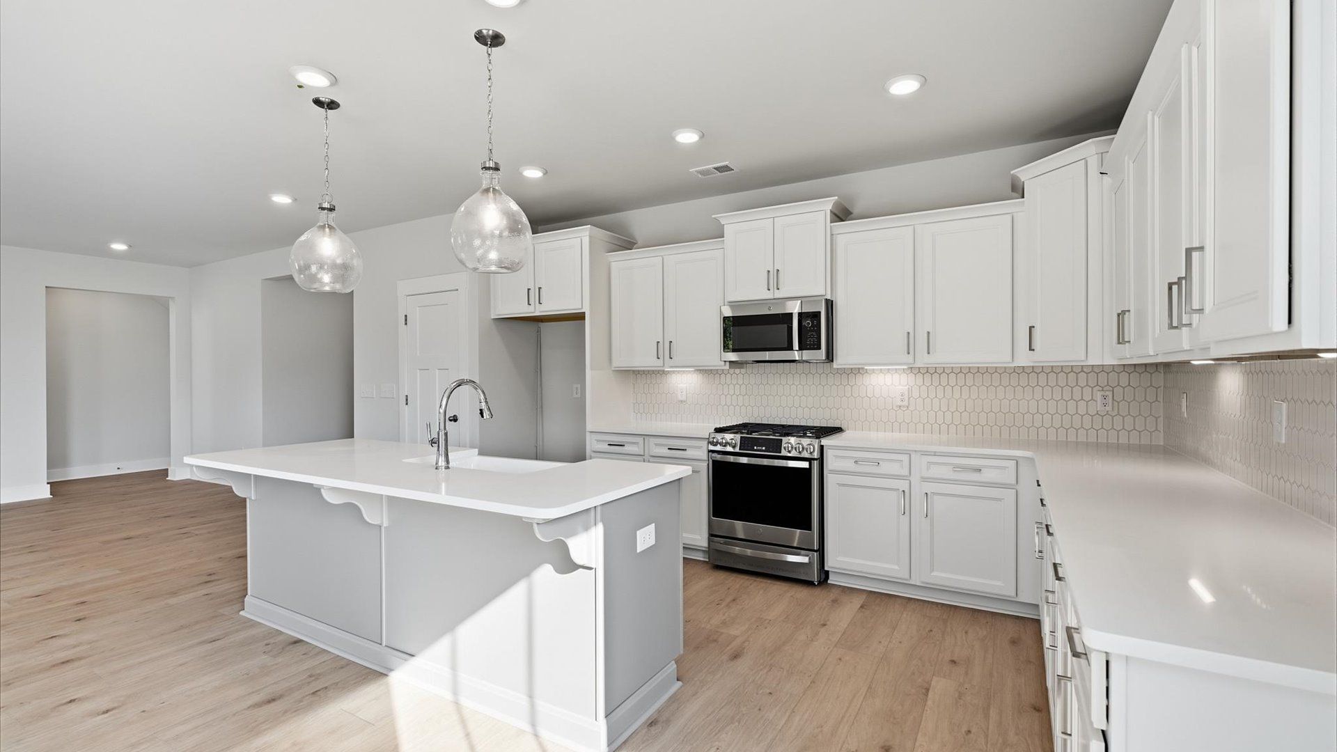 Highly skilled craftsmanship shines in this modern kitchen with pendant lighting and a central island focal point