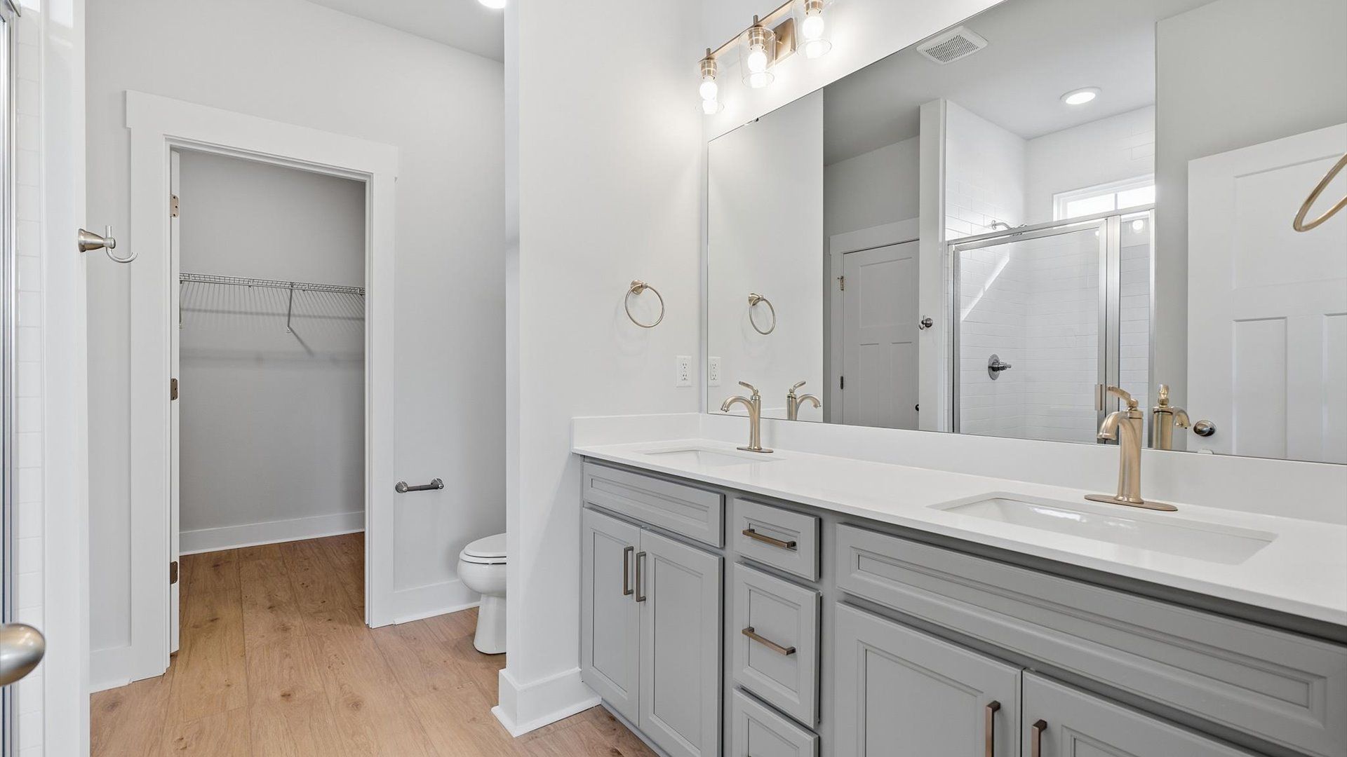 Sophisticated primary bathroom with expansive vanity and polished hardware at the Wells Crossing community