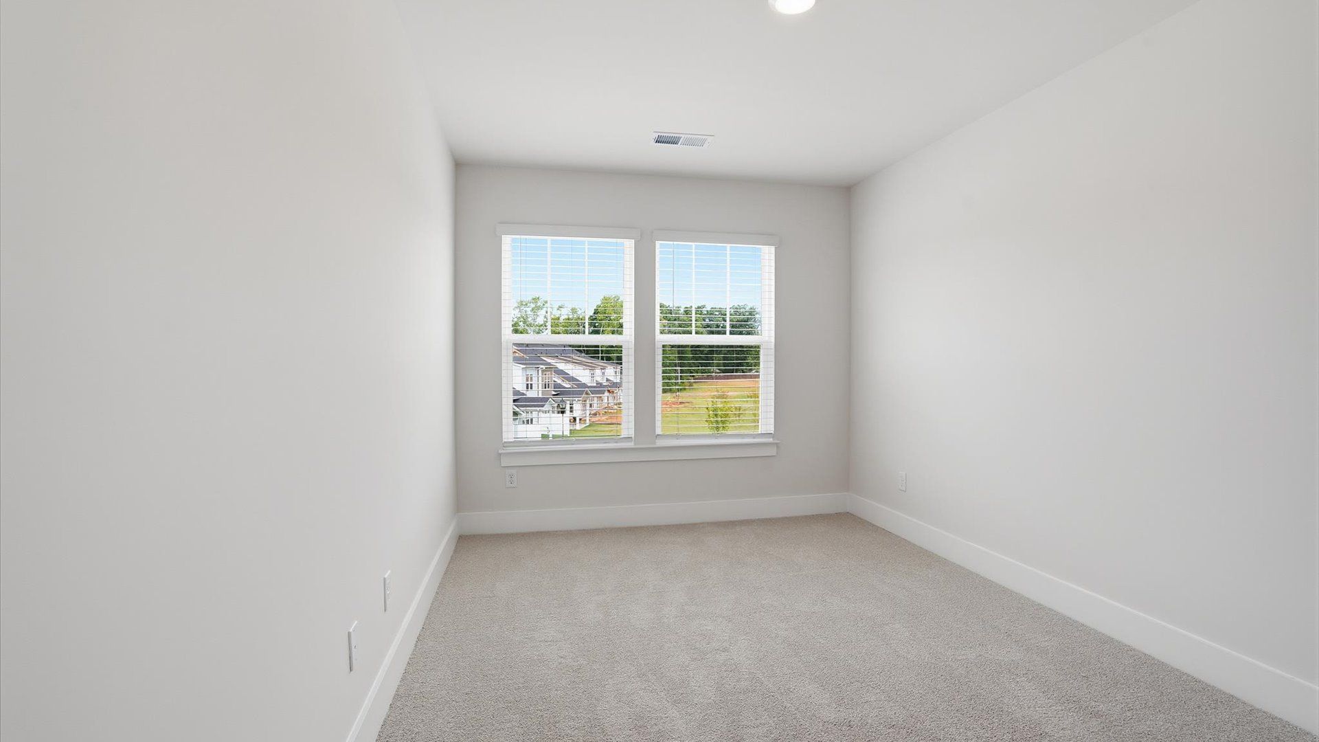 Notable bedroom offering soft carpet, a walk-in closet, and expansive windows overlooking the yard by DRB Homes