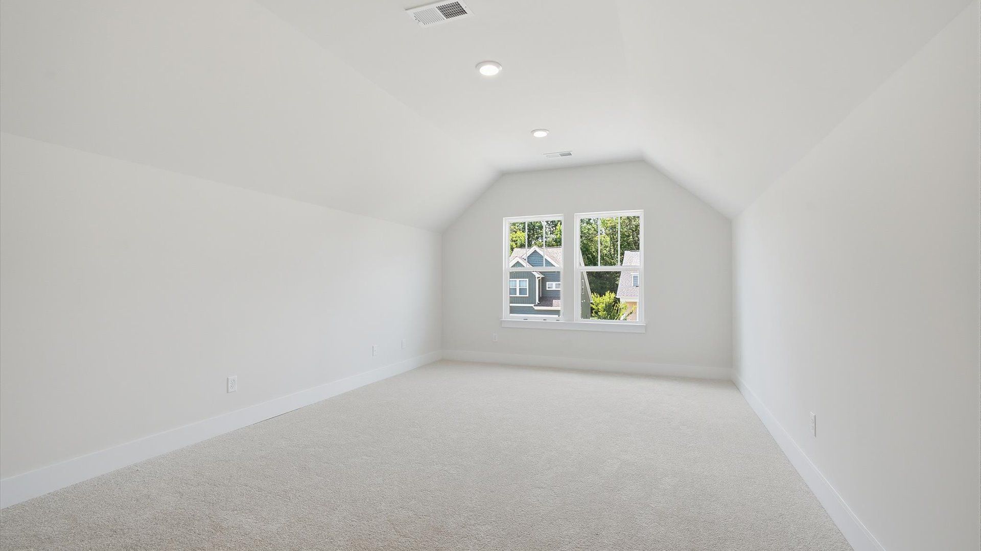 Stylish bonus room retreat with carpeted flooring and accomplished architectural detail at Iris Meadows