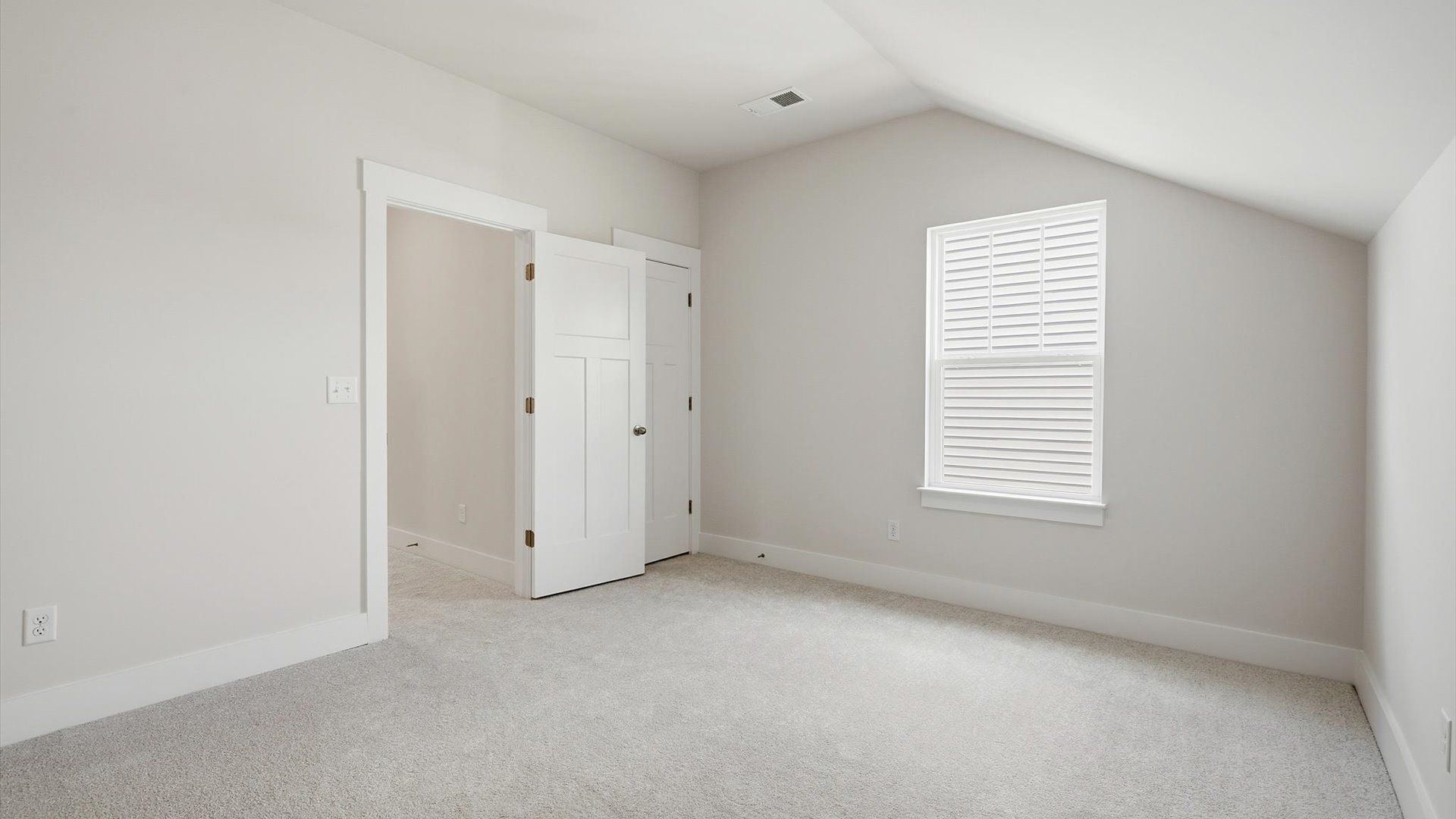 Refined bedroom design with a large window for daylight-filled mornings and peaceful views by DRB Homes
