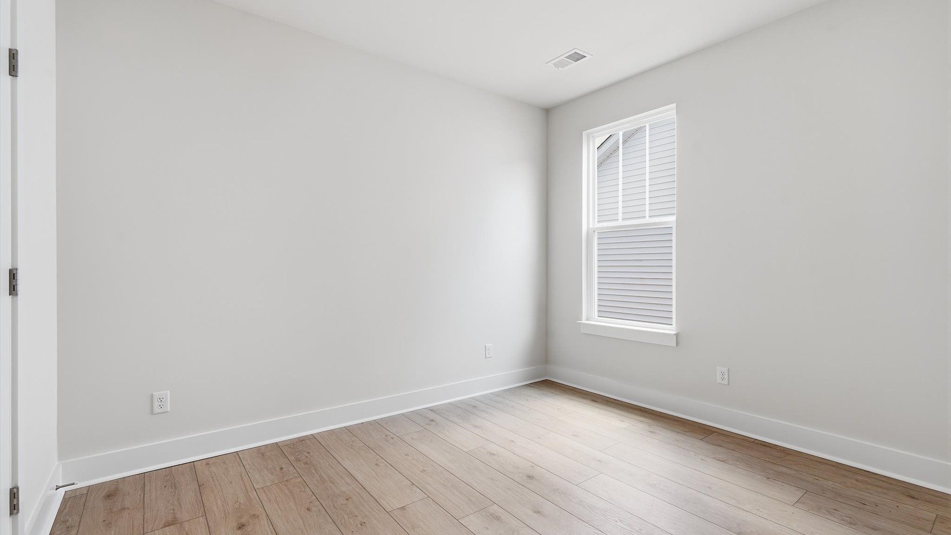 Vibrant and restful bedroom with an oversized window, refined detail, and a warm, welcoming atmosphere