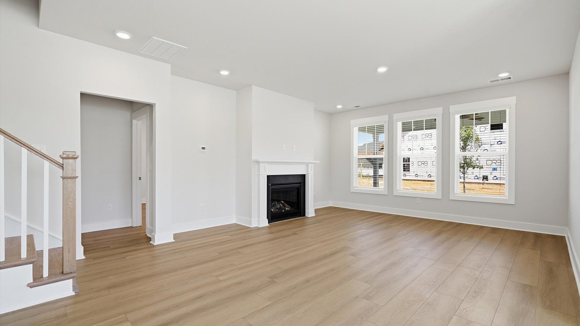 Elegant family room featuring hardwood flooring, large windows, and thoughtful architectural detail in Inman, SC