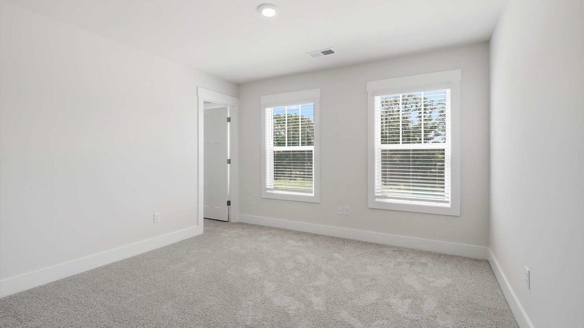 Inviting bedroom with tasteful finishes and large windows that create a fresh, open ambiance by DRB Homes