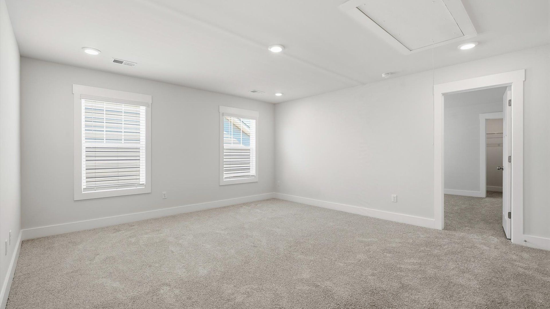 Vibrant carpeted loft offering flexibility as a study nook, game room, or second family space by DRB Homes