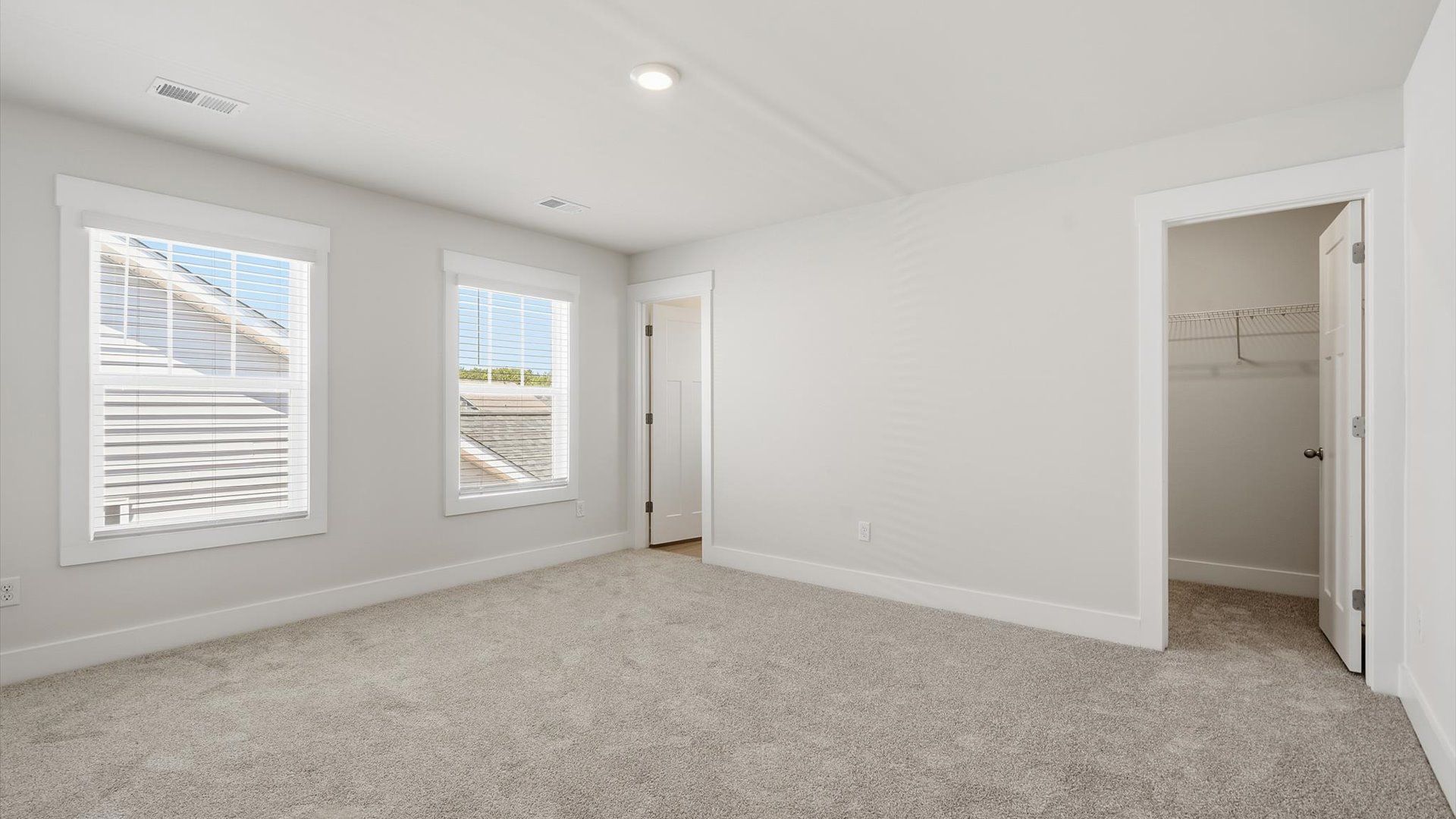 Elegant guest bedroom retreat featuring soft carpeting and a thoughtfully designed walk-in closet in Inman, SC