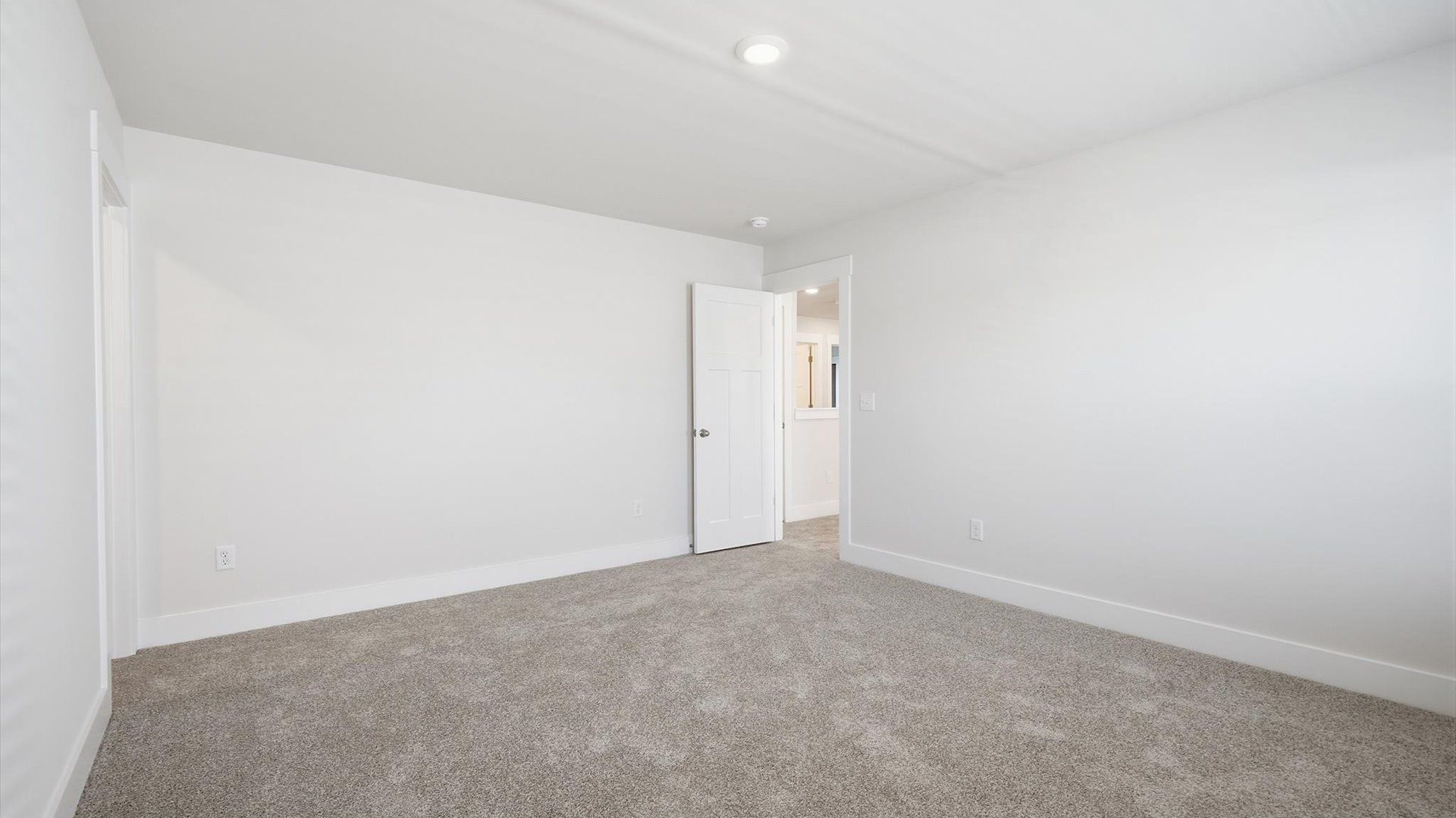 Tasteful bedroom with plush carpet, a walk-in closet, and large windows for abundant natural light by DRB Homes
