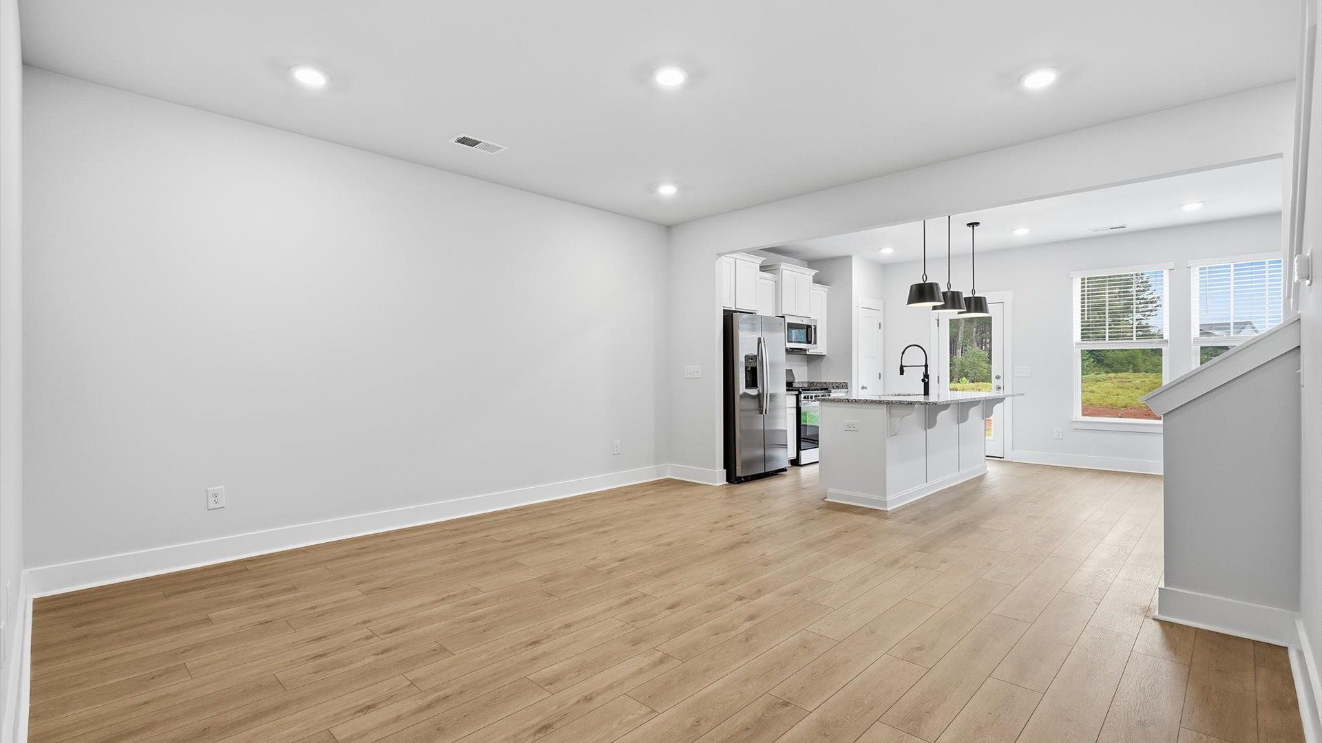 Hardwood flooring and high standards define this vibrant family room ideal for everyday living by DRB Homes