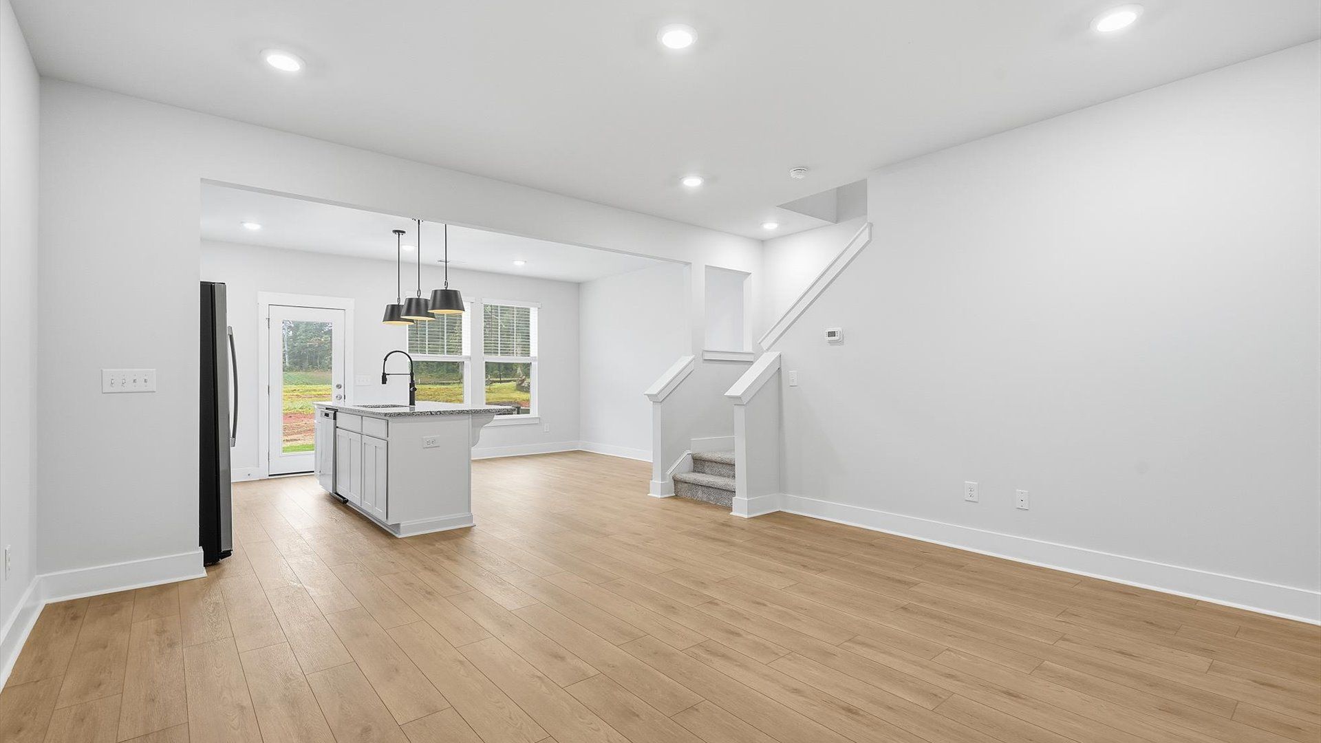 Memorable moments begin in this elegant, open family room with hardwood flooring and refined finishes at Aspen Ridge