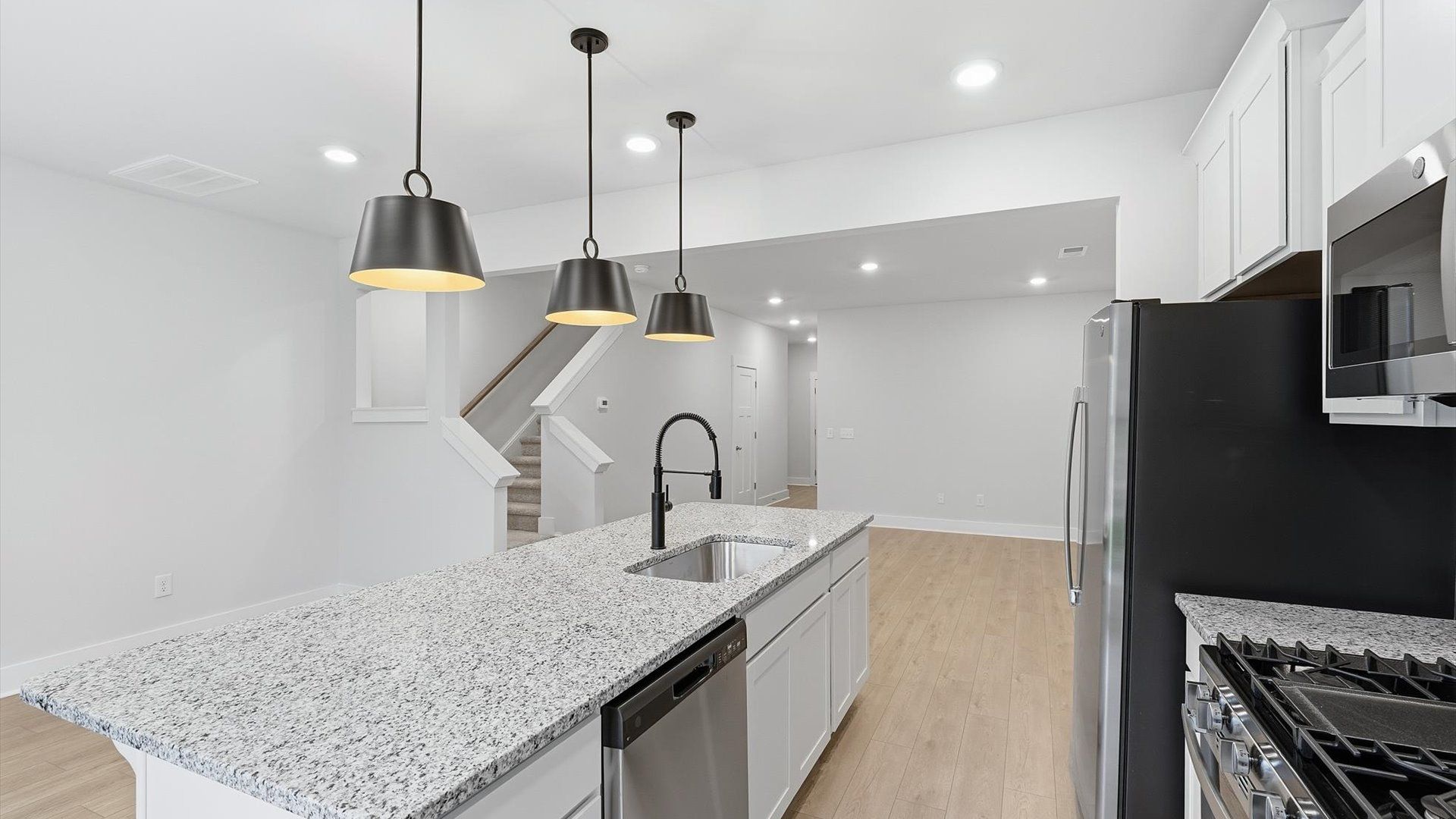 Bright and airy culinary space with generous prep areas and contemporary lighting at the Aspen Ridge community