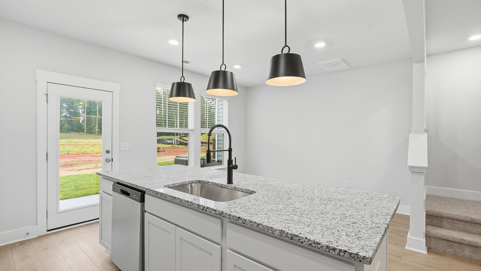 Exclusive kitchen design with large island, pendant lights, and tasteful finishes throughout by DRB Homes
