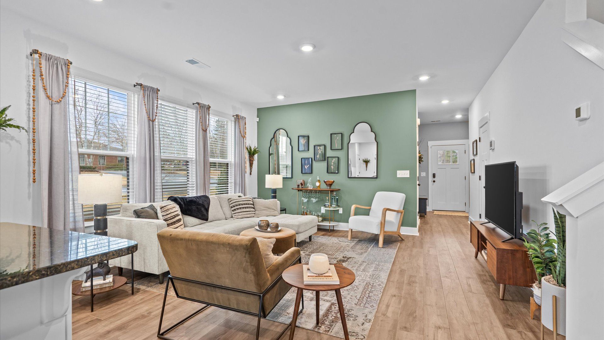 Elegant family room featuring hardwood flooring, large windows, and thoughtful architectural detail in Hendersonville, NC