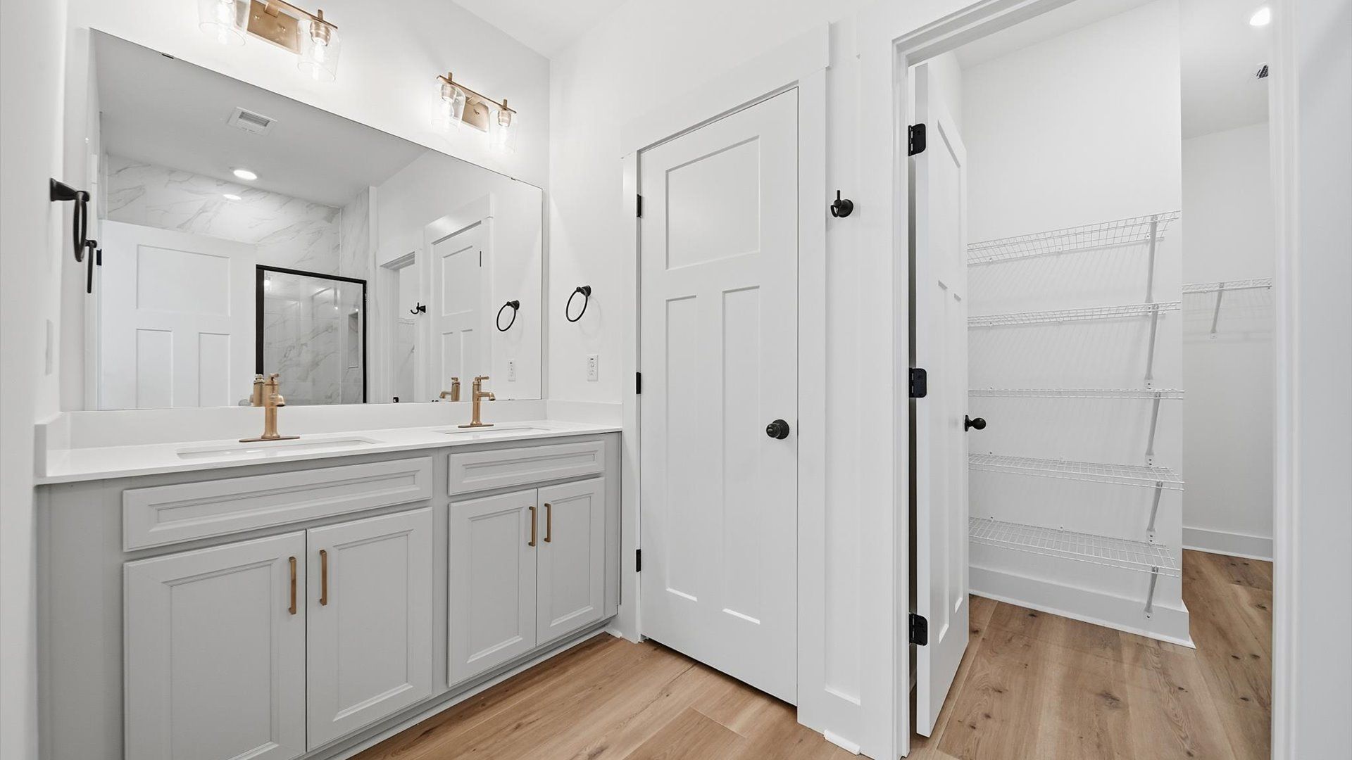 Superior en-suite primary bathroom with stylish dual vanity and tiled walk-in shower—crafted with high standards in mind