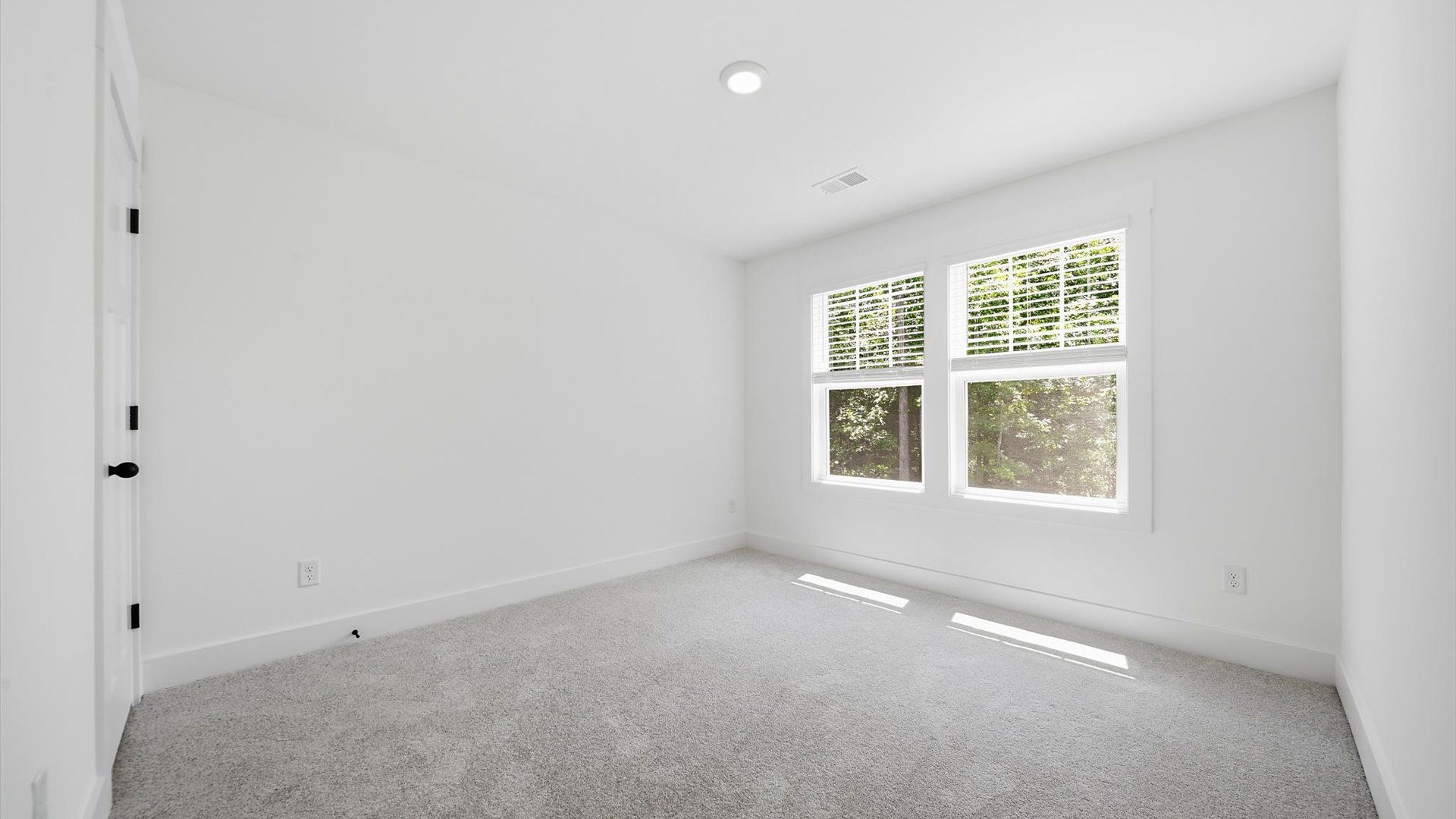 Notable secondary bedroom offering cozy carpeted flooring and a stylish walk-in closet
