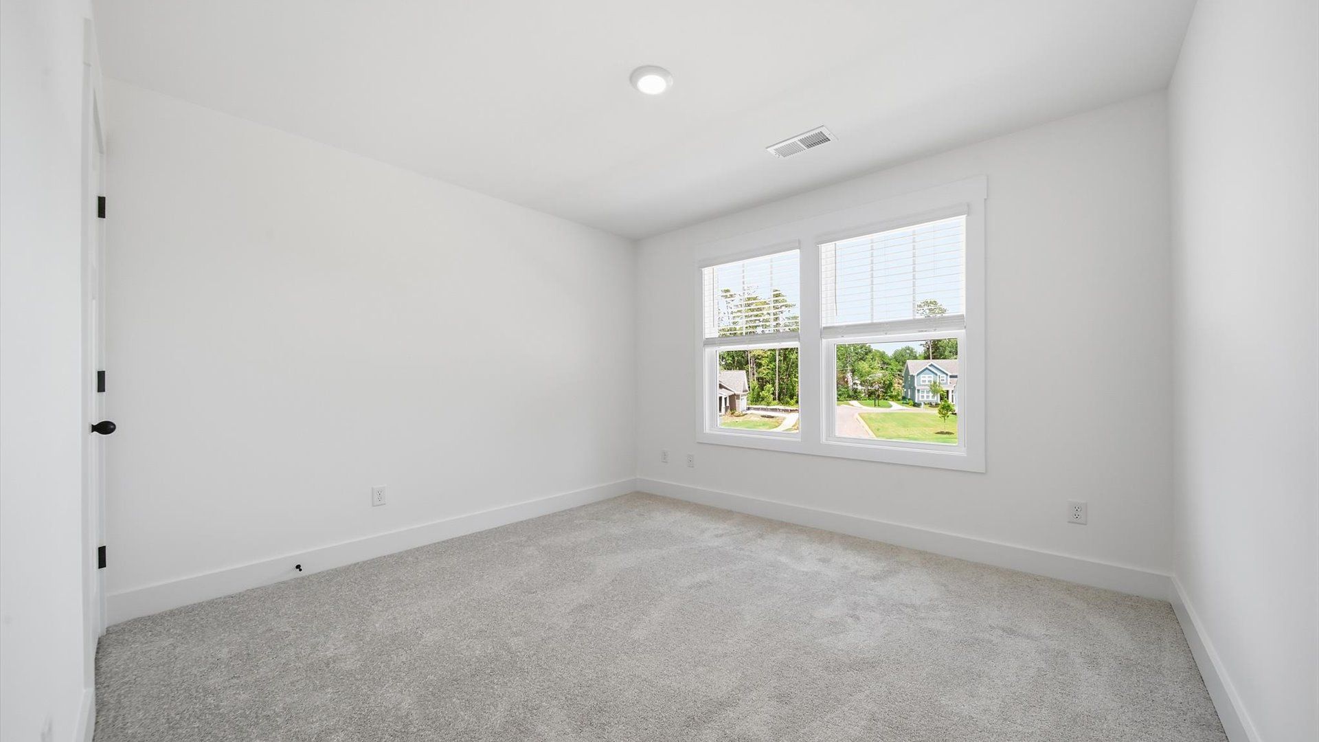 Tasteful secondary bedroom with plush carpet and a spacious walk-in closet
