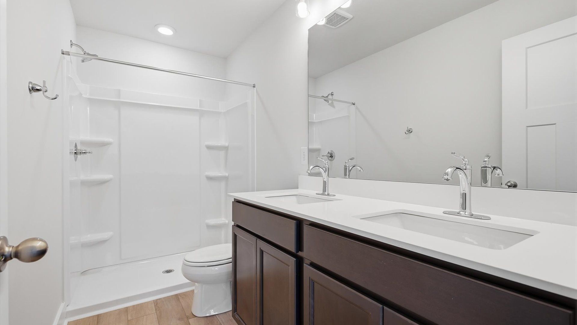 Elegant primary bathroom featuring a spacious walk-in shower and dual vanity in this first-class DRB Homes design