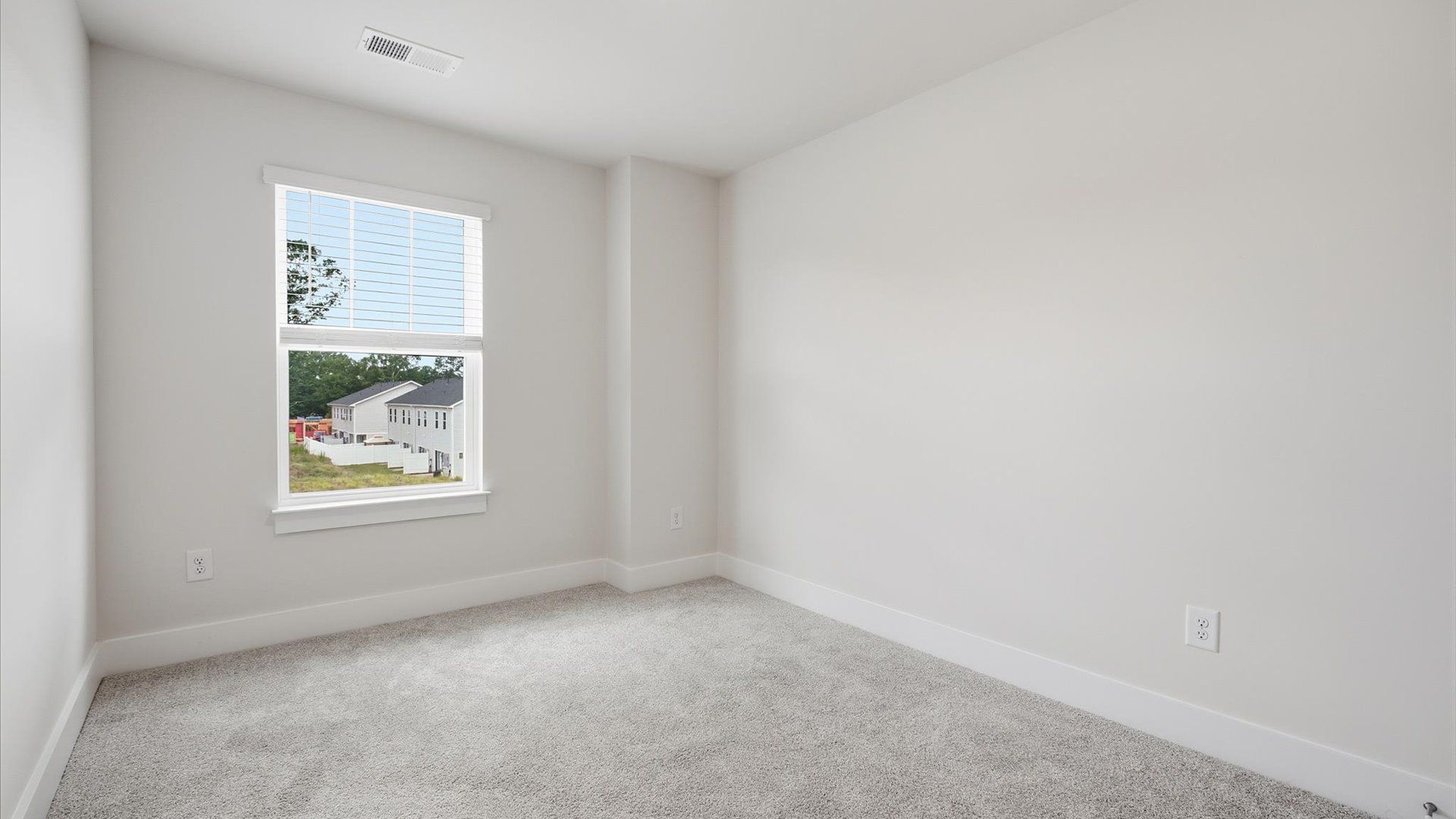 Tasteful secondary bedroom with plush carpet and a spacious walk-in closet