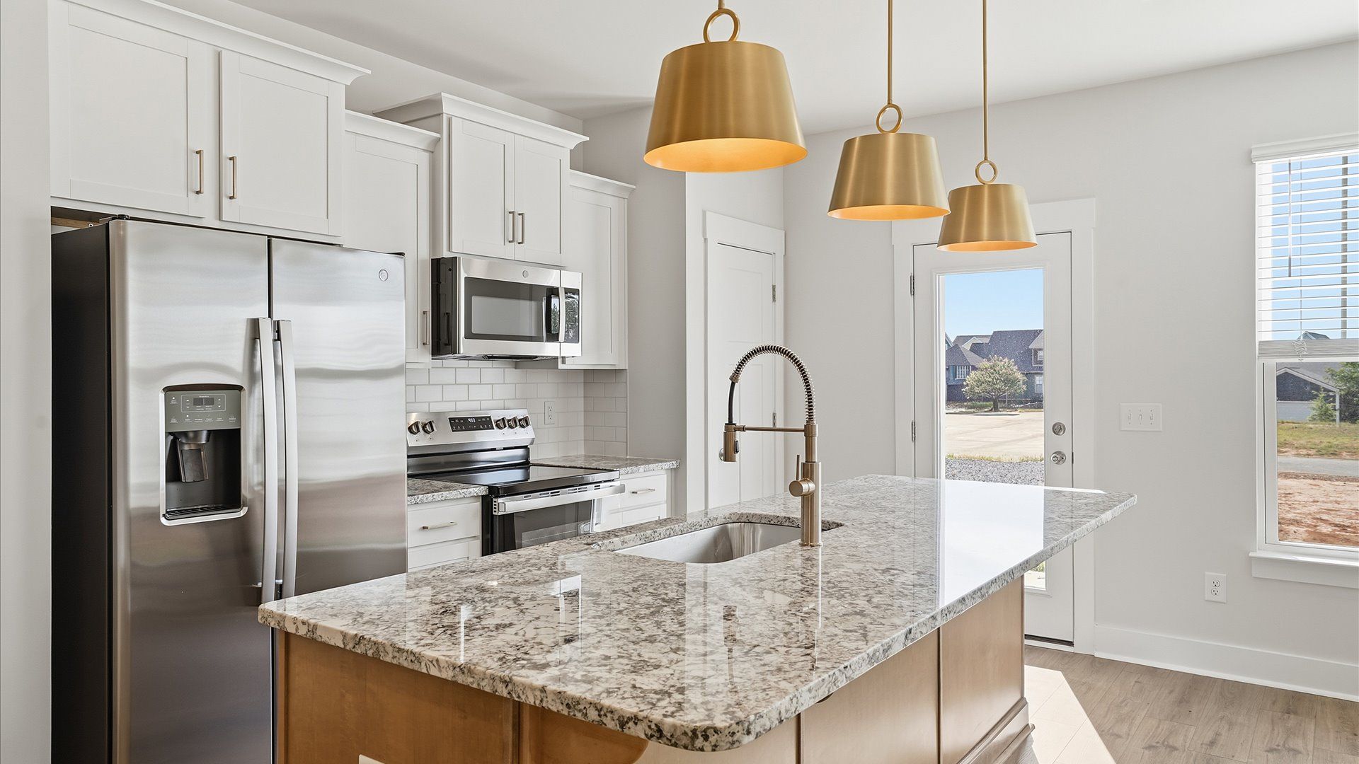 Notable kitchen space with elegant pendant lighting and a large island perfect for entertaining at Gresham Station