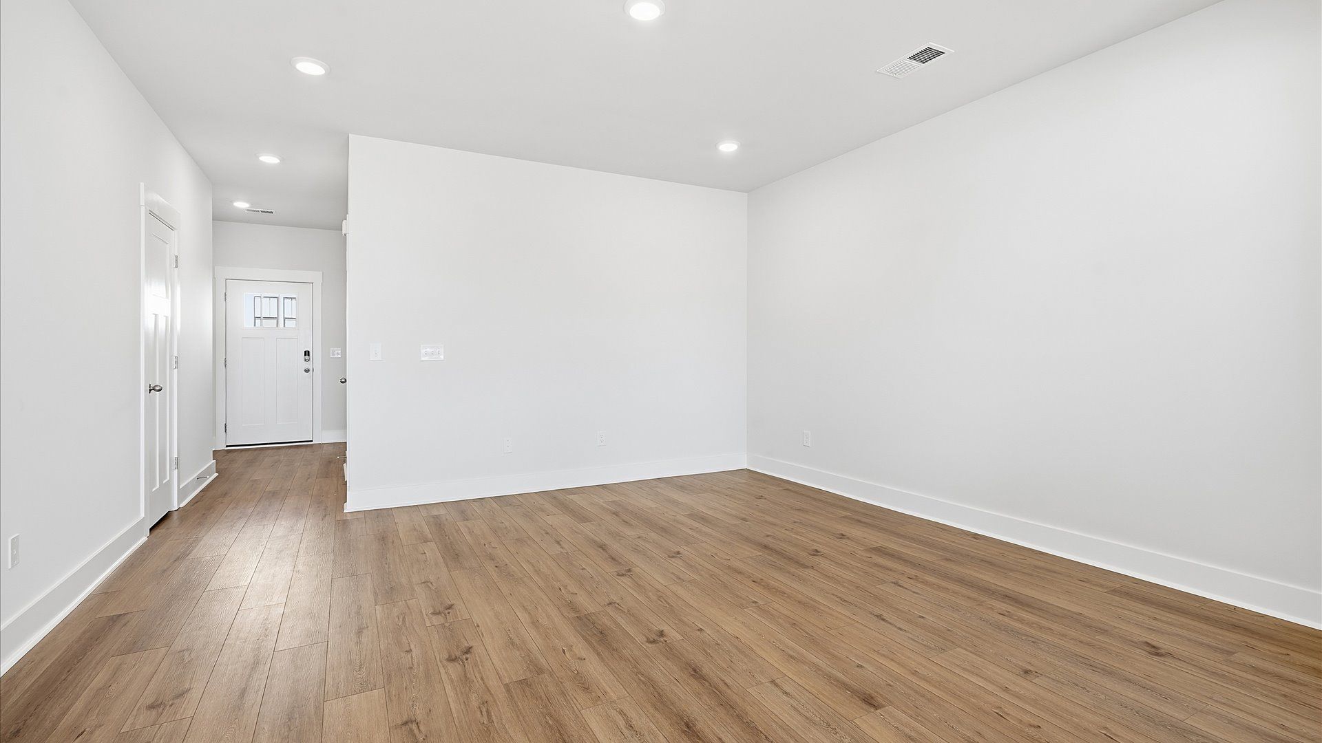 Spacious family room with rich hardwood flooring and elegant trim work in a reputable DRB Homes build