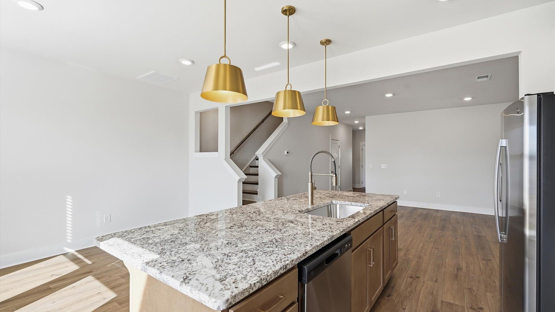 Exceptional kitchen featuring a spacious island, eye-catching pendant lights, and modern finishes at Gresham Station
