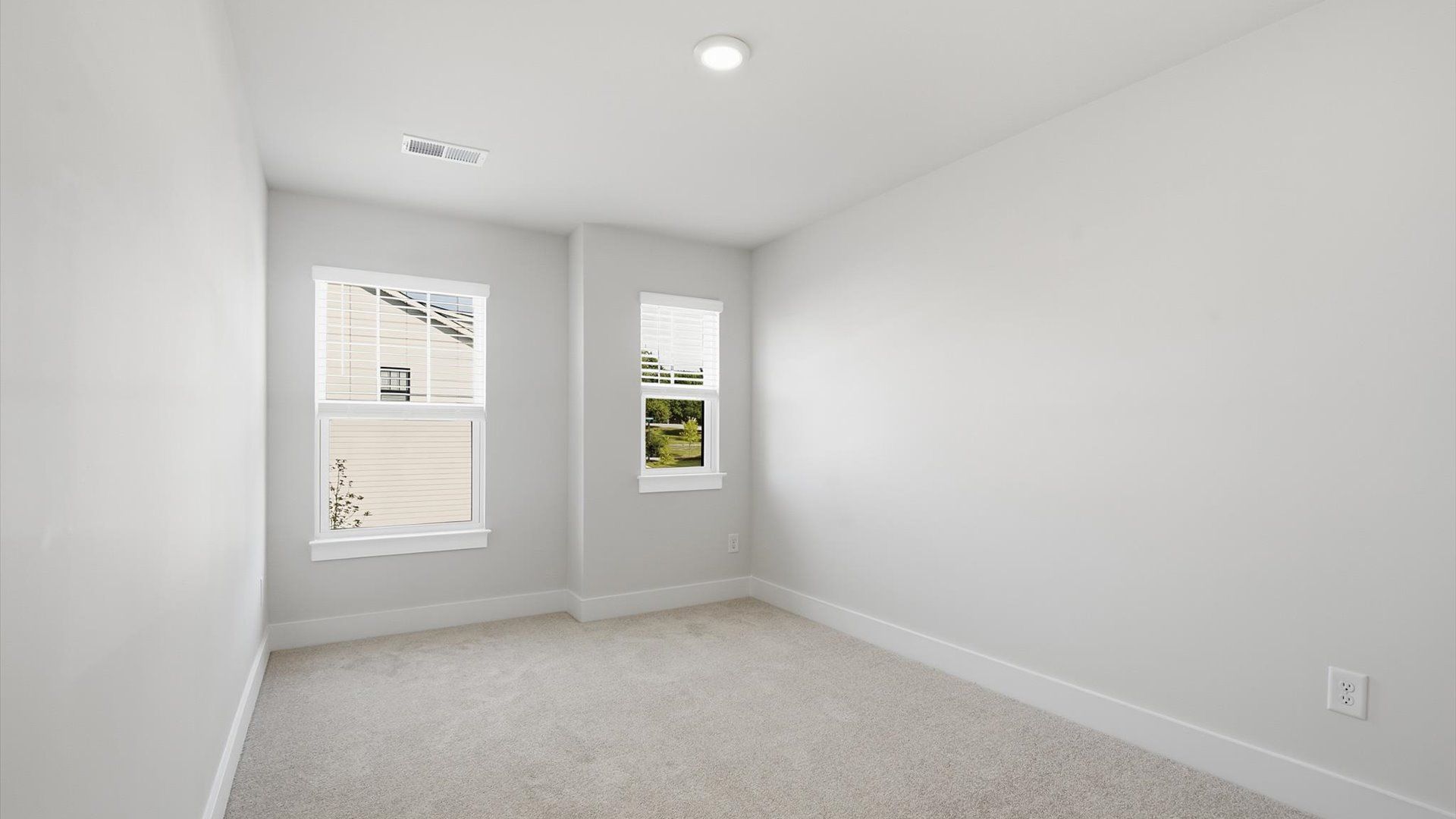 Accomplished design in this restful bedroom featuring plush carpet and oversized window views by DRB Homes