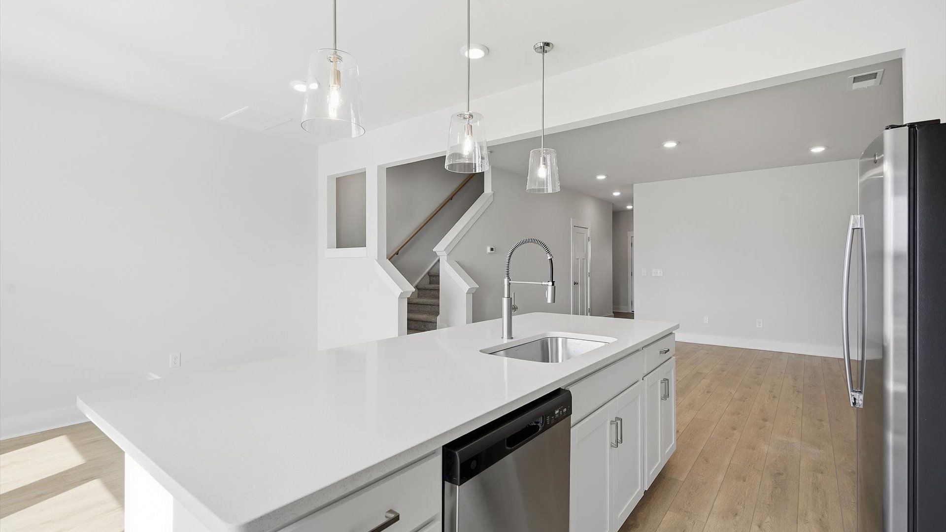 Tasteful design meets functional luxury in this kitchen with a center island and modern pendant lighting
