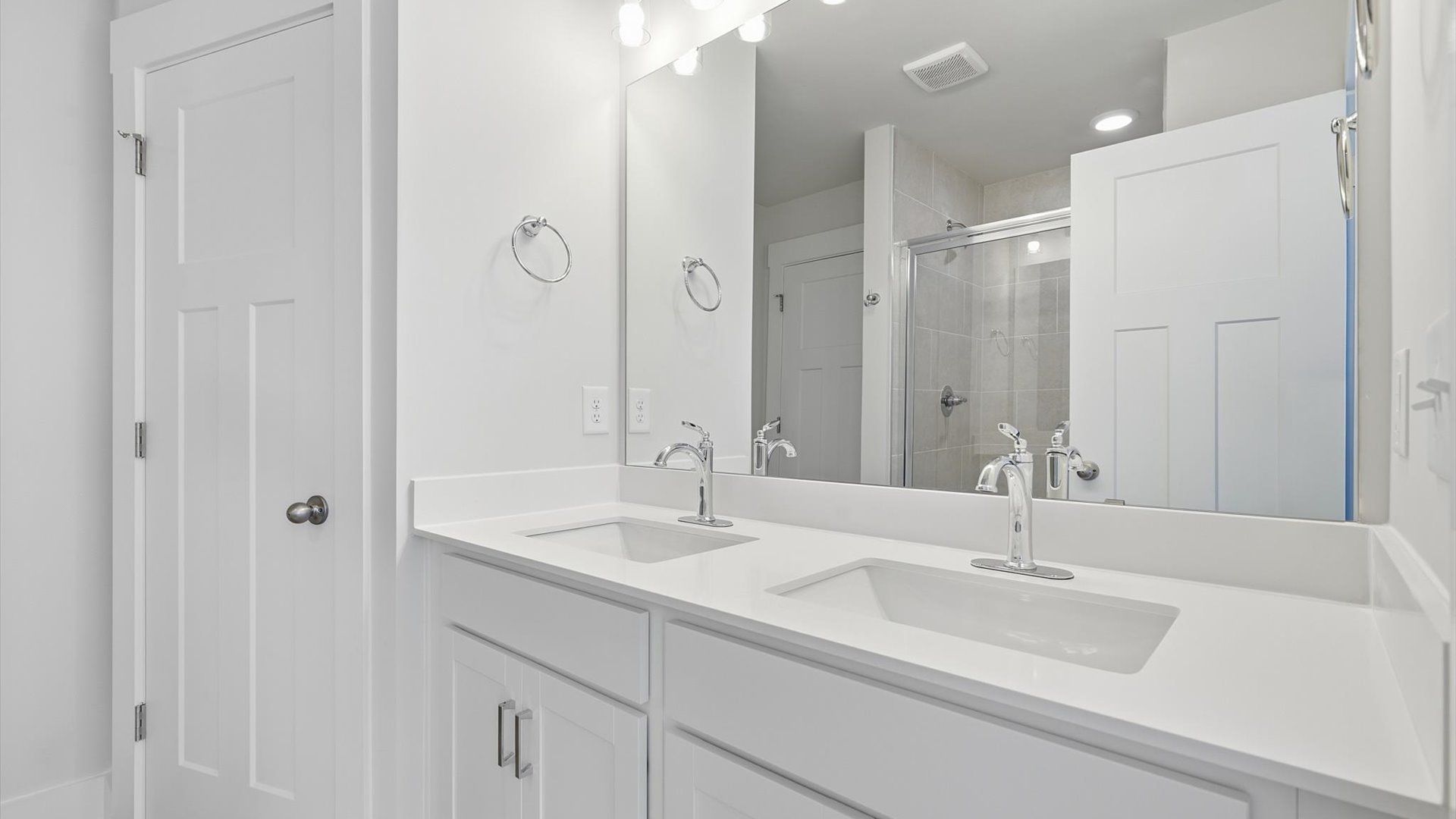 Accomplished design shines in this primary bath with dual vanity and a sleek walk-in shower by DRB Homes