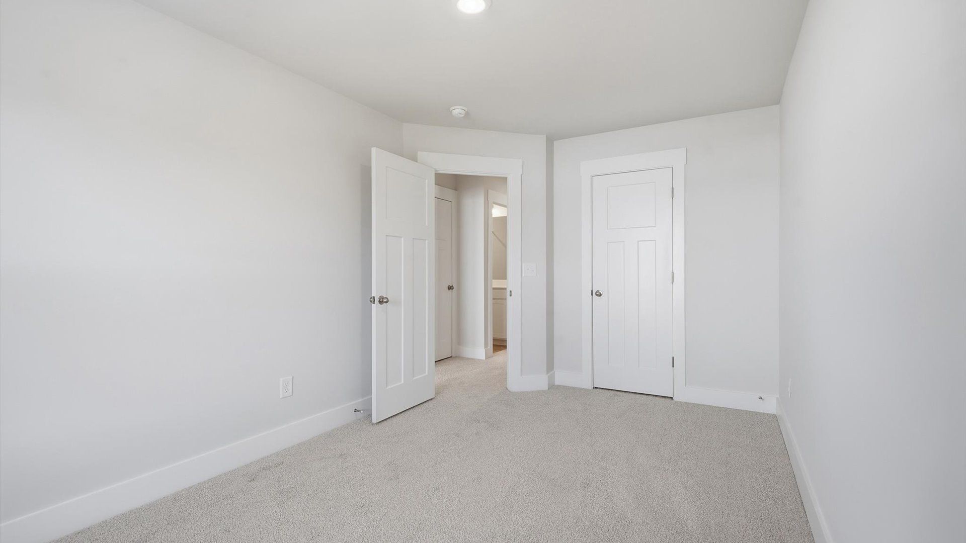 Highly functional bedroom with walk-in closet and tasteful carpet for a restful retreat by DRB Homes