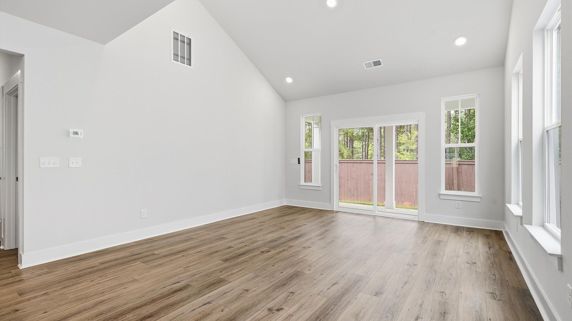 Tasteful family room with two-story volume, refined finishes, and exceptional natural light
