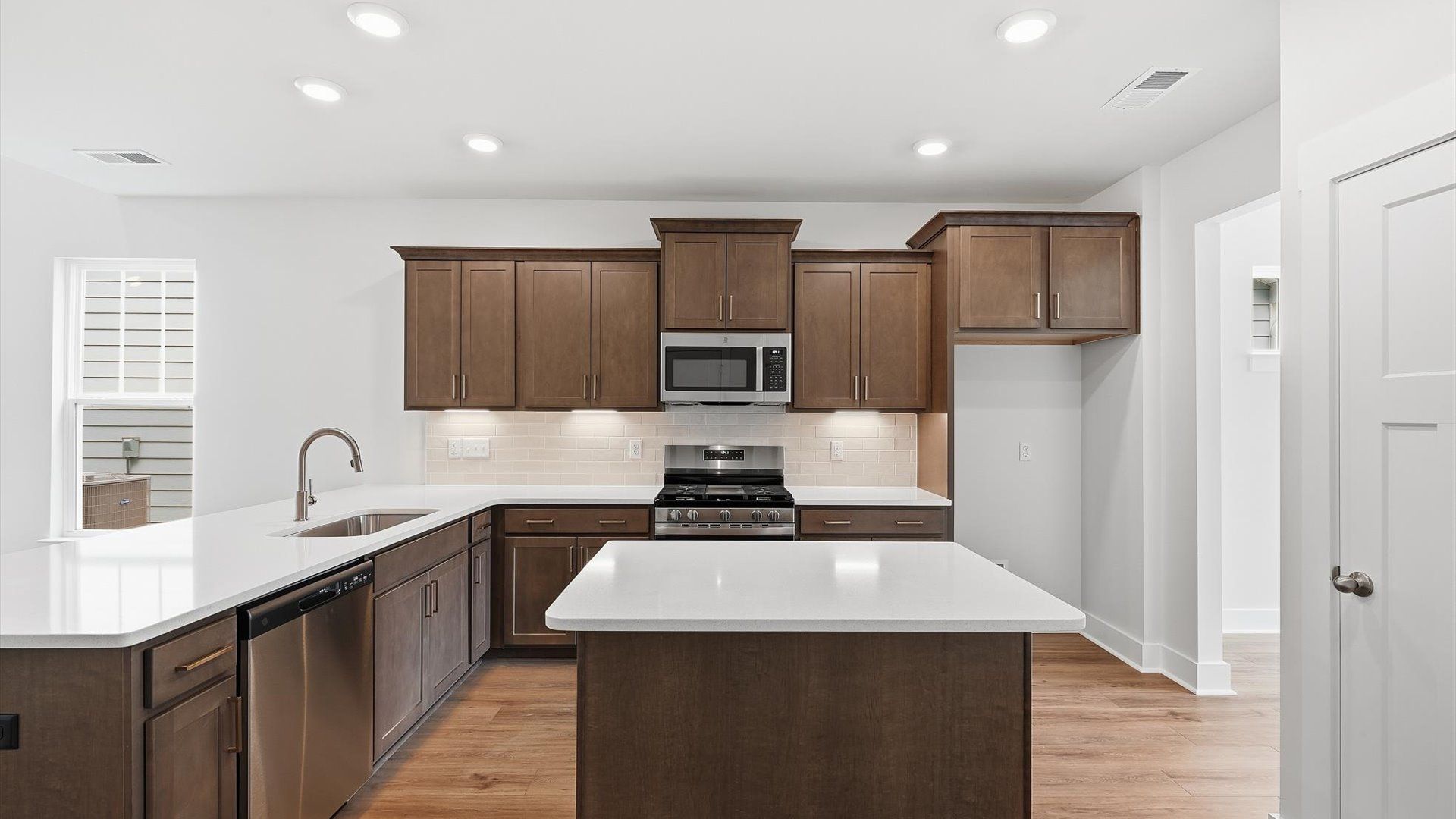 Highly skilled craftsmanship shines in this modern kitchen with pendant lighting and a central island focal point
