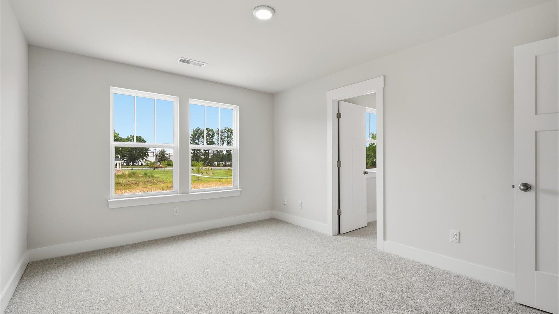 Vibrant and restful bedroom with oversized windows, refined detail, and a warm, welcoming atmosphere