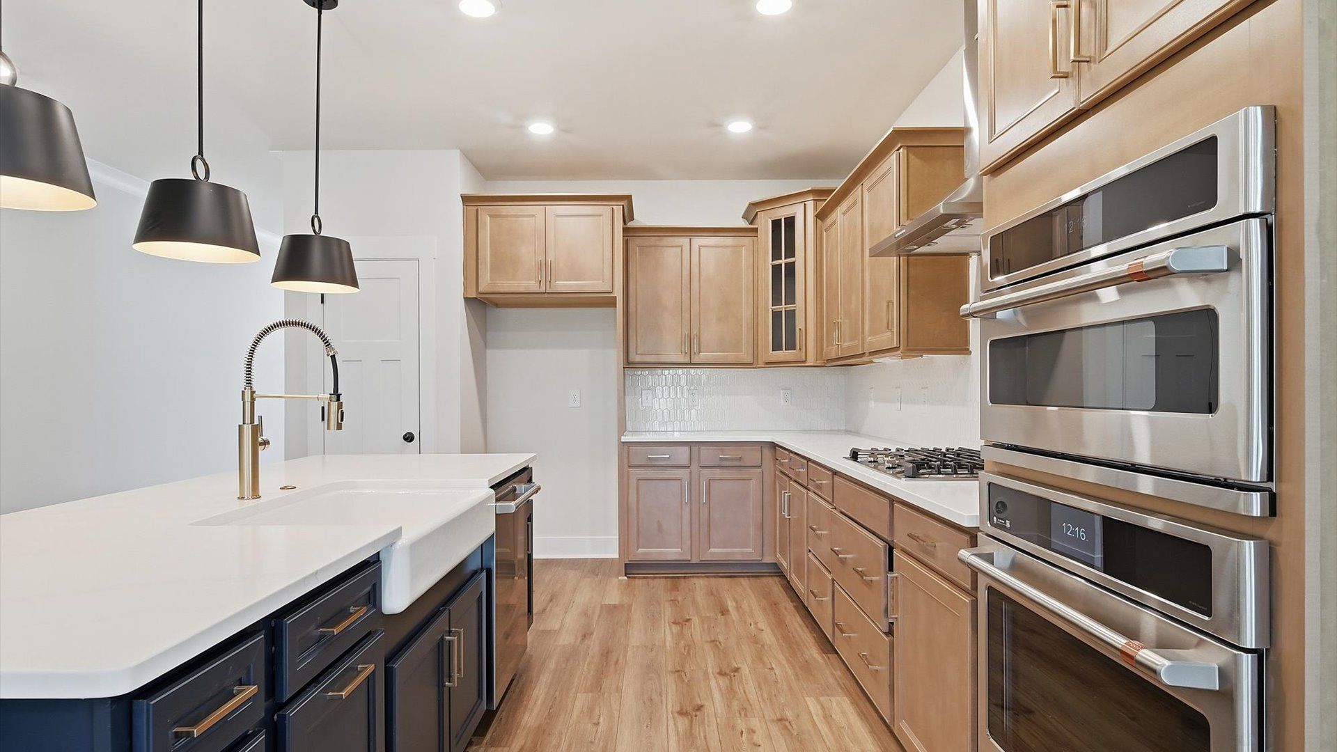 Exceptional kitchen featuring a spacious island, eye-catching pendant lights, and modern finishes at Harrier Point