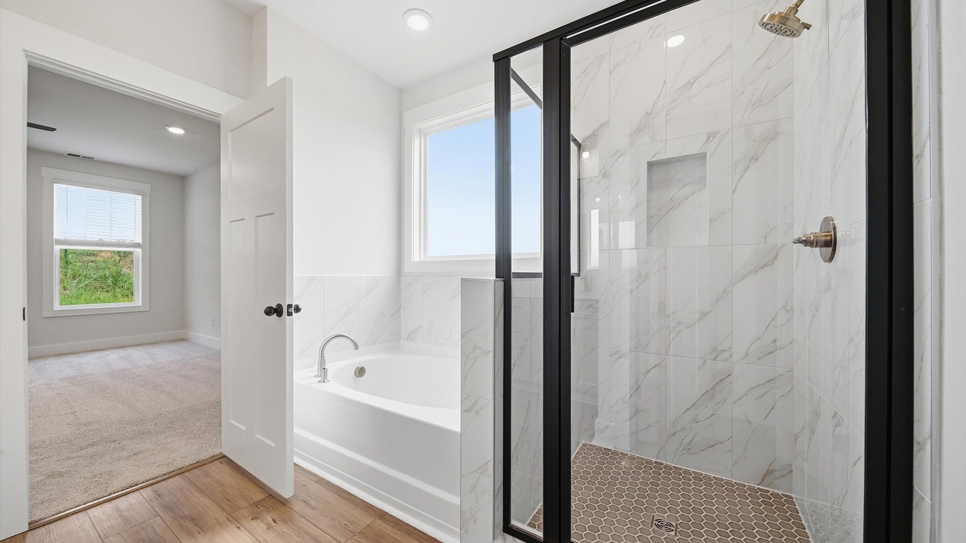 Spacious and modern primary bathroom with walk-in shower and first-class soaking tub at Harrier Point