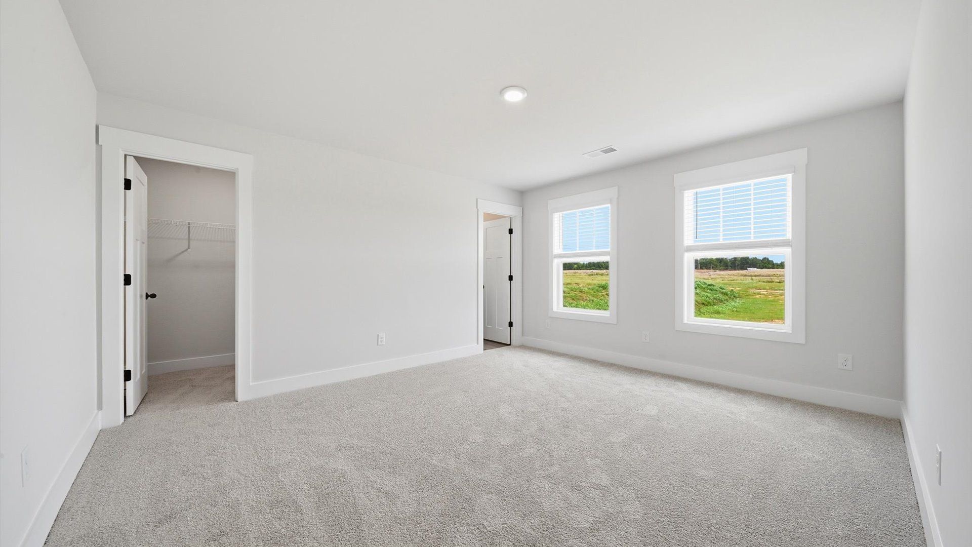 Highly functional bedroom with large windows, carpeted flooring, and tasteful finishes throughout in Woodruff, SC