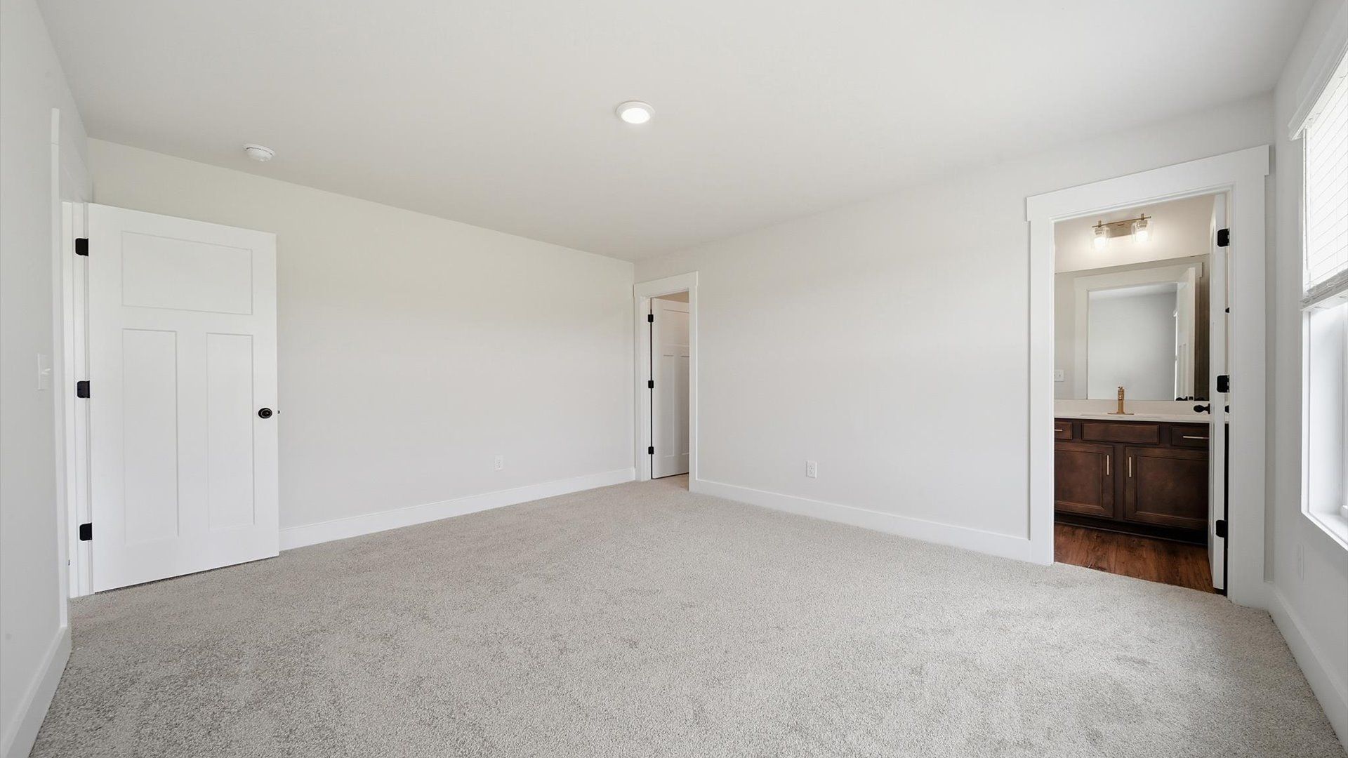 Elegant bedroom retreat featuring soft carpeting and a thoughtfully designed walk-in closet by DRB Homes