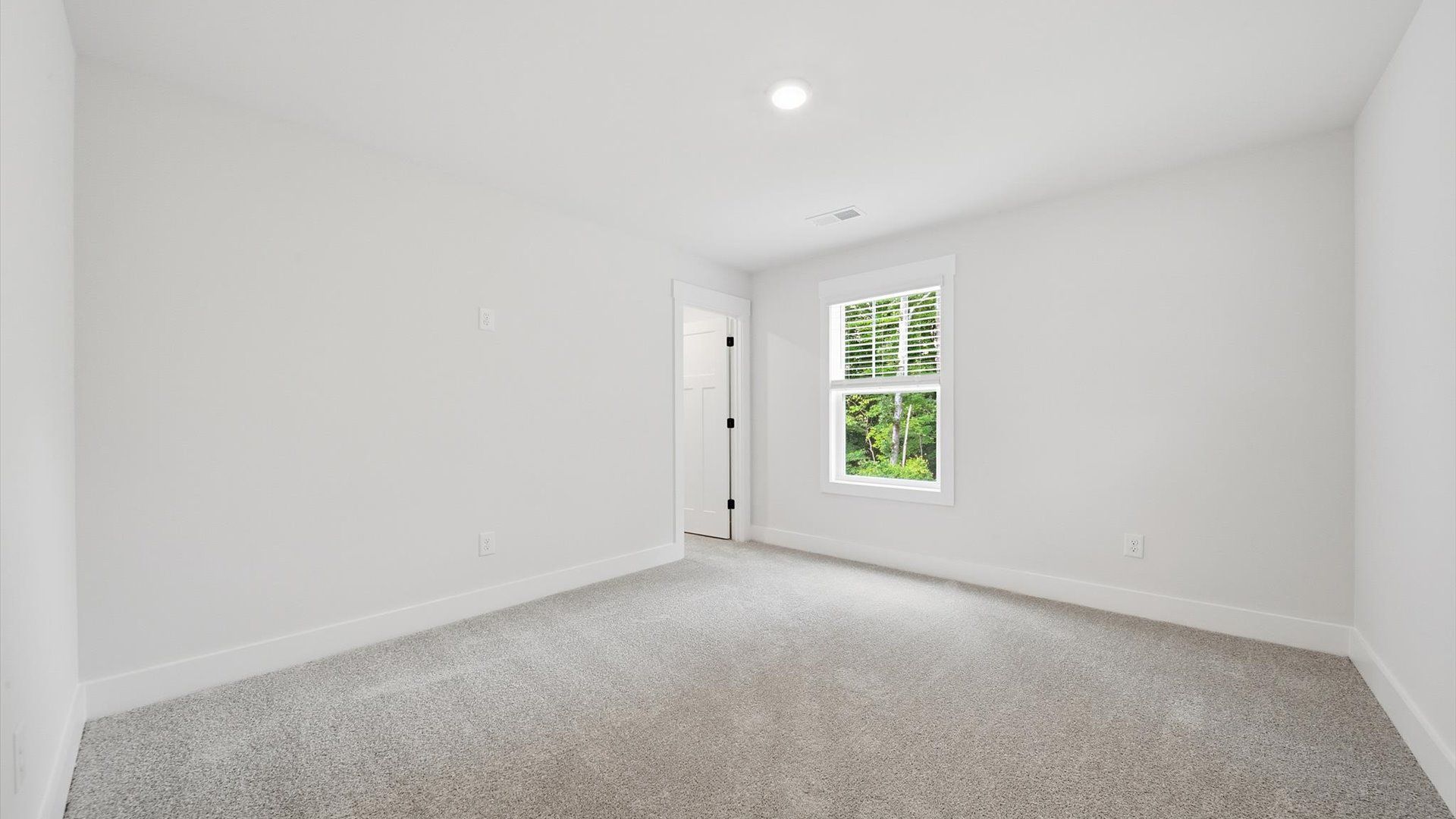 Functional secondary bedroom with carpeted flooring and modern touches in an exceptional layout
