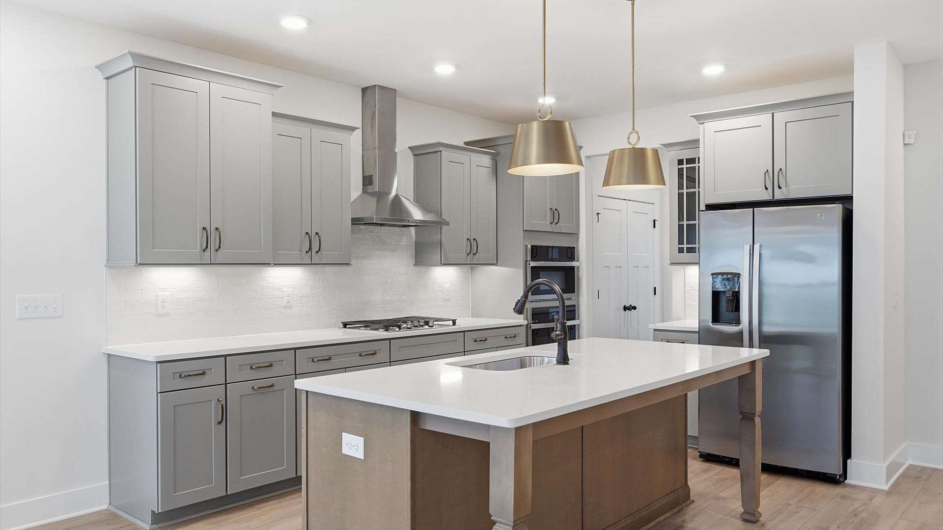 Elegant and compact island anchors this tasteful kitchen with high standards and timeless appeal by DRB Homes