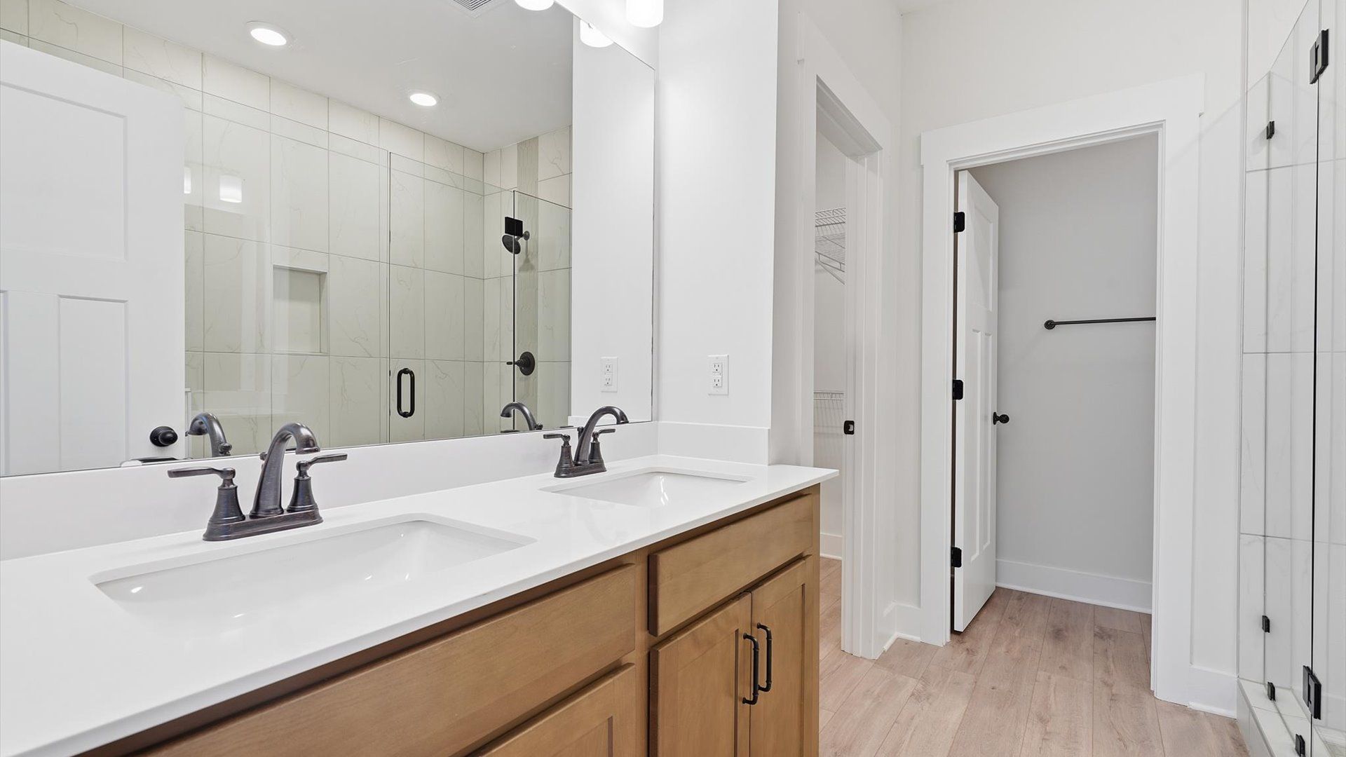 Notable primary bath featuring dual vanity, walk-in shower, and tasteful design touches throughout by DRB Homes