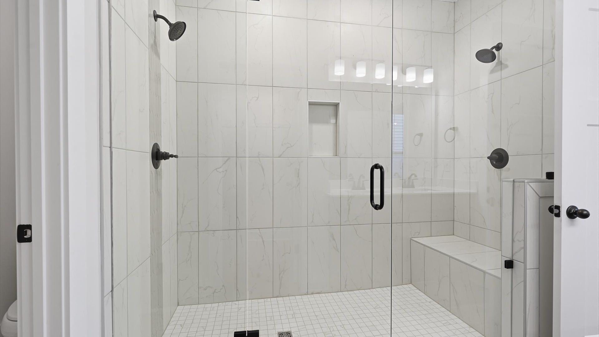 Accomplished design shines in this primary bath with dual vanity and a sleek walk-in shower at Fox Hollow