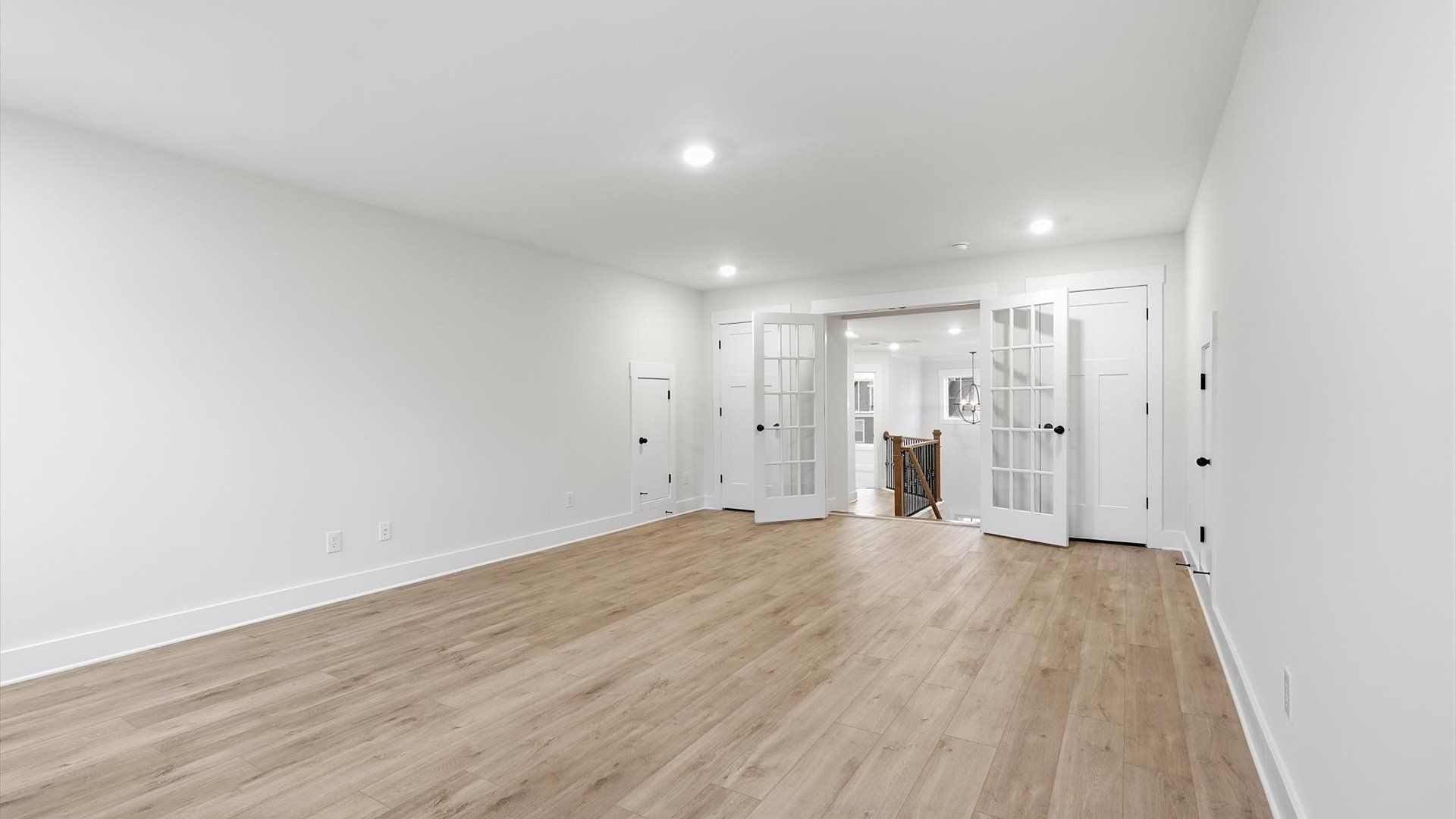 Stylish bonus room with hardwood flooring, French doors and accomplished architectural detail by DRB Homes