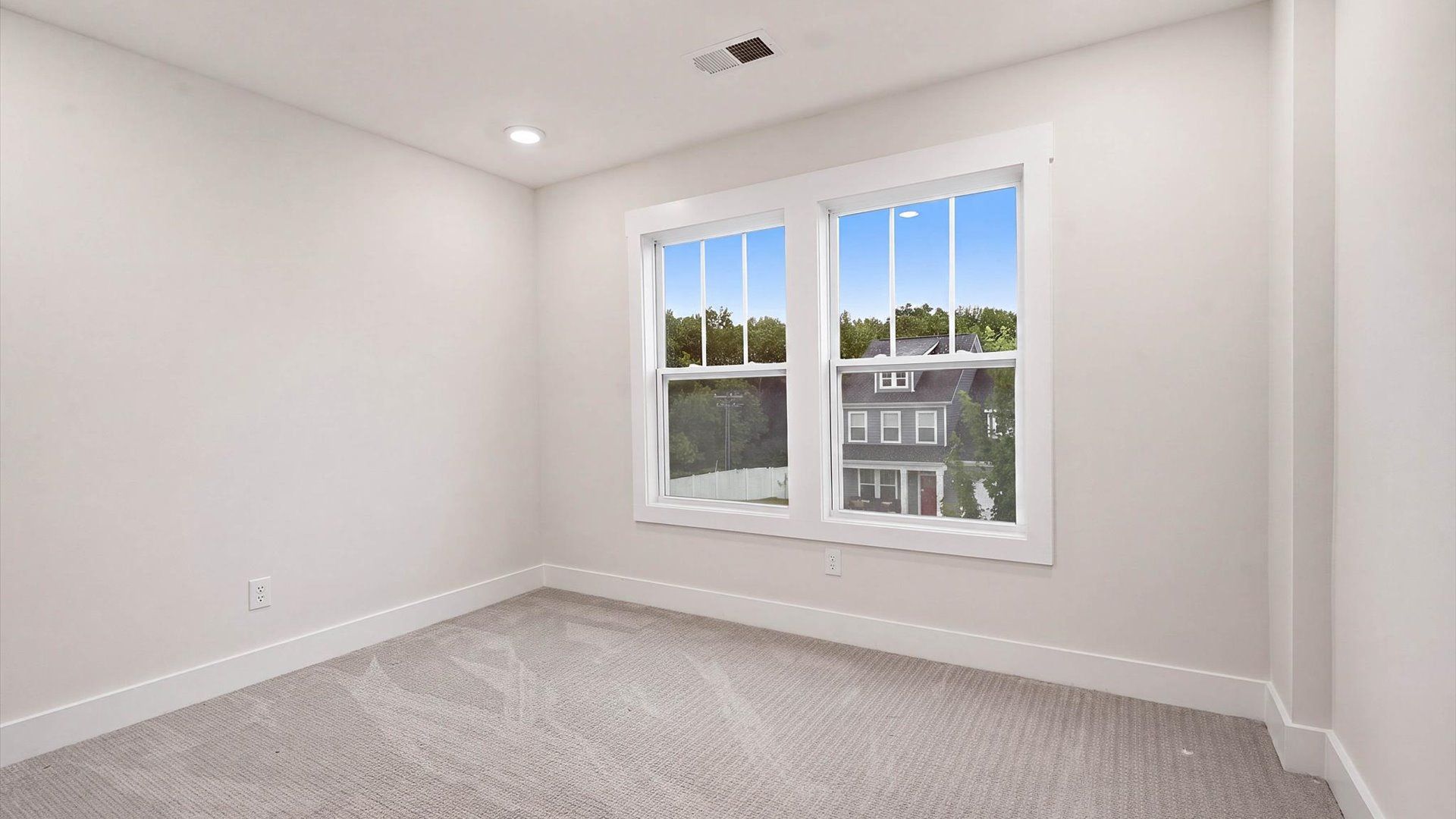 First-rate bedroom with plush carpeting and large windows that provide an open, airy feel at the Fox Hollow community