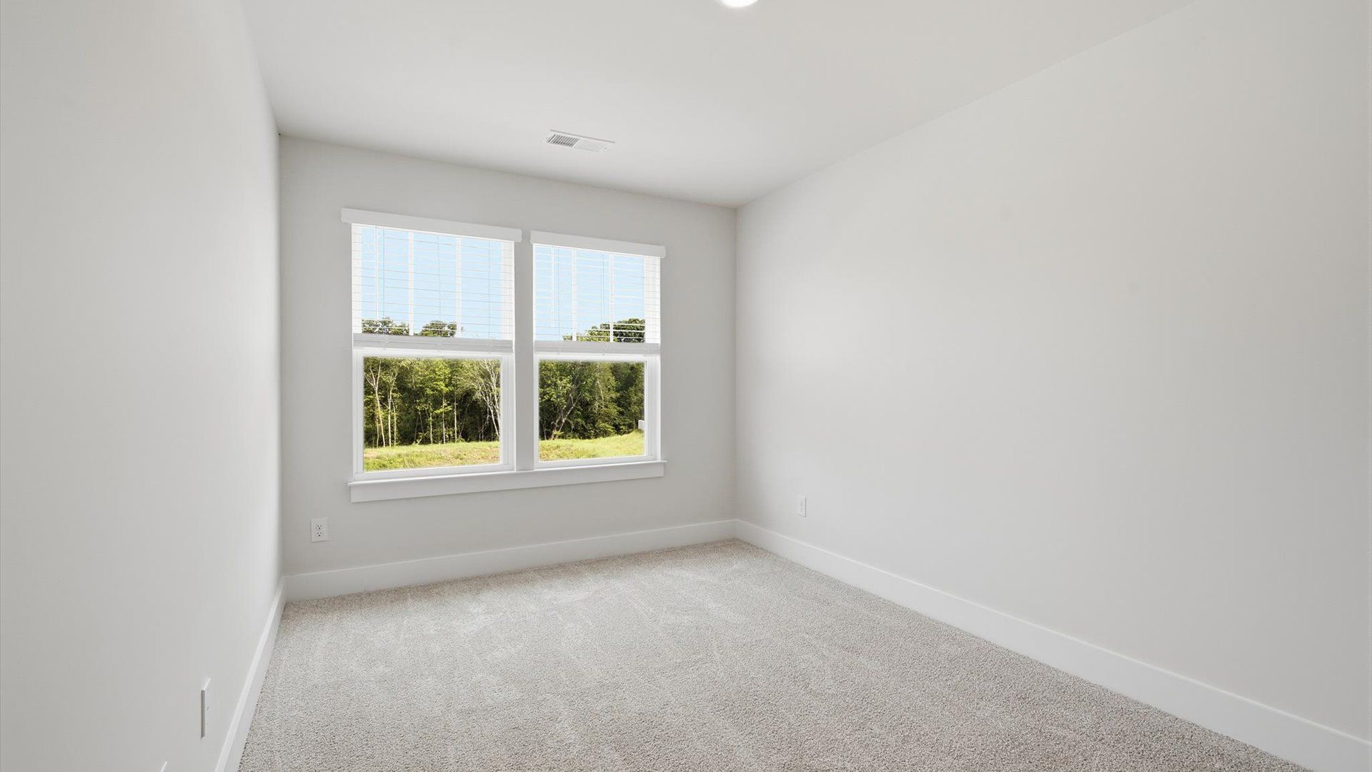 Elegant bedroom retreat featuring soft carpet and oversized windows that create a bright, welcoming space