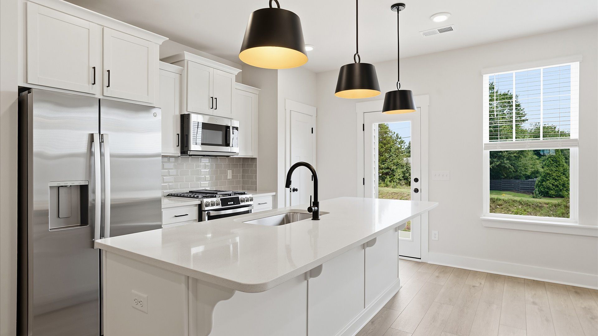 Tasteful design meets functional luxury in this kitchen with a 9-foot island and modern pendant lighting